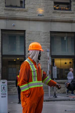 Construction worker in orange jumpsuit and hard hat