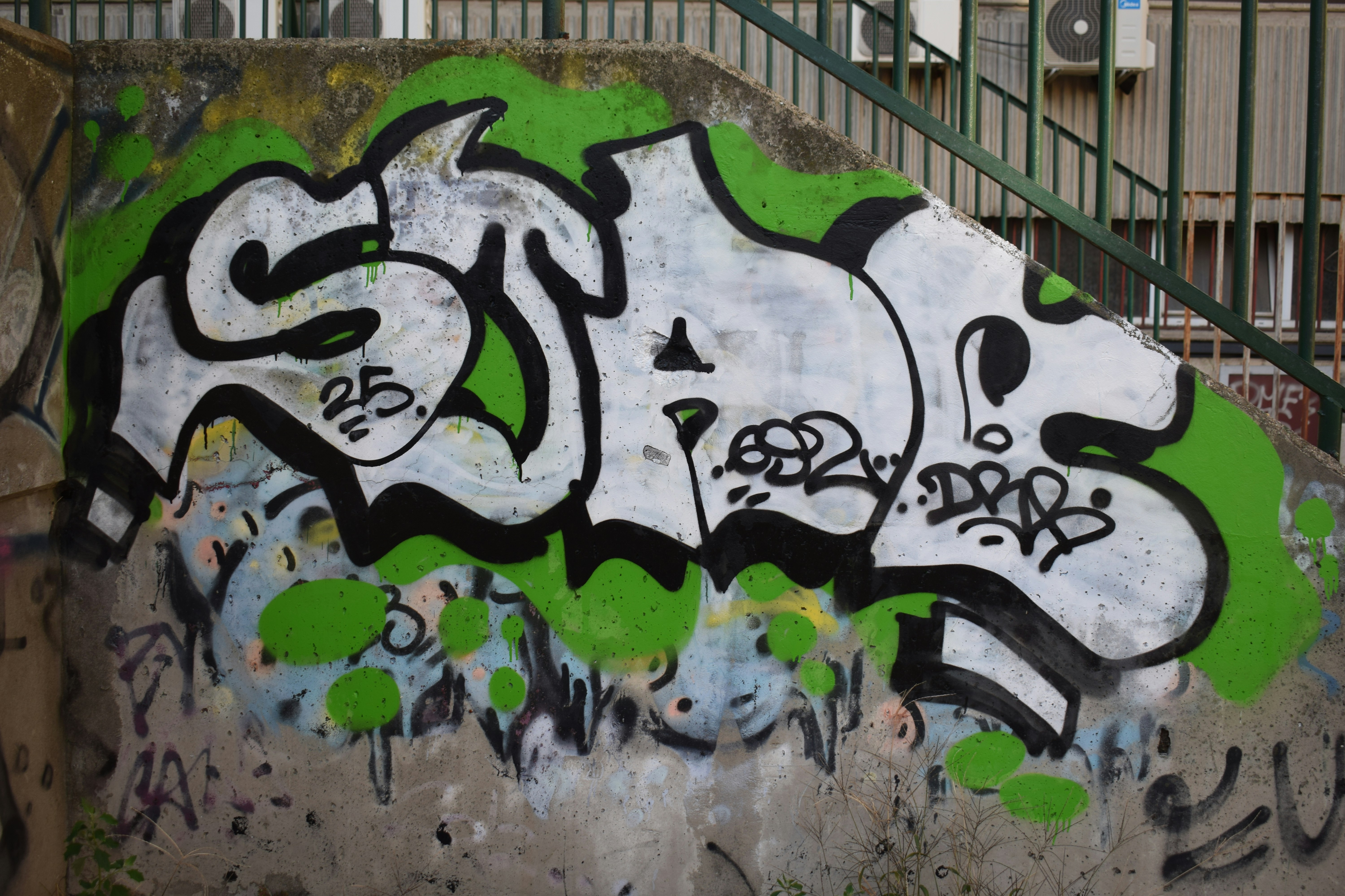 Graffiti art on a concrete wall with green accents