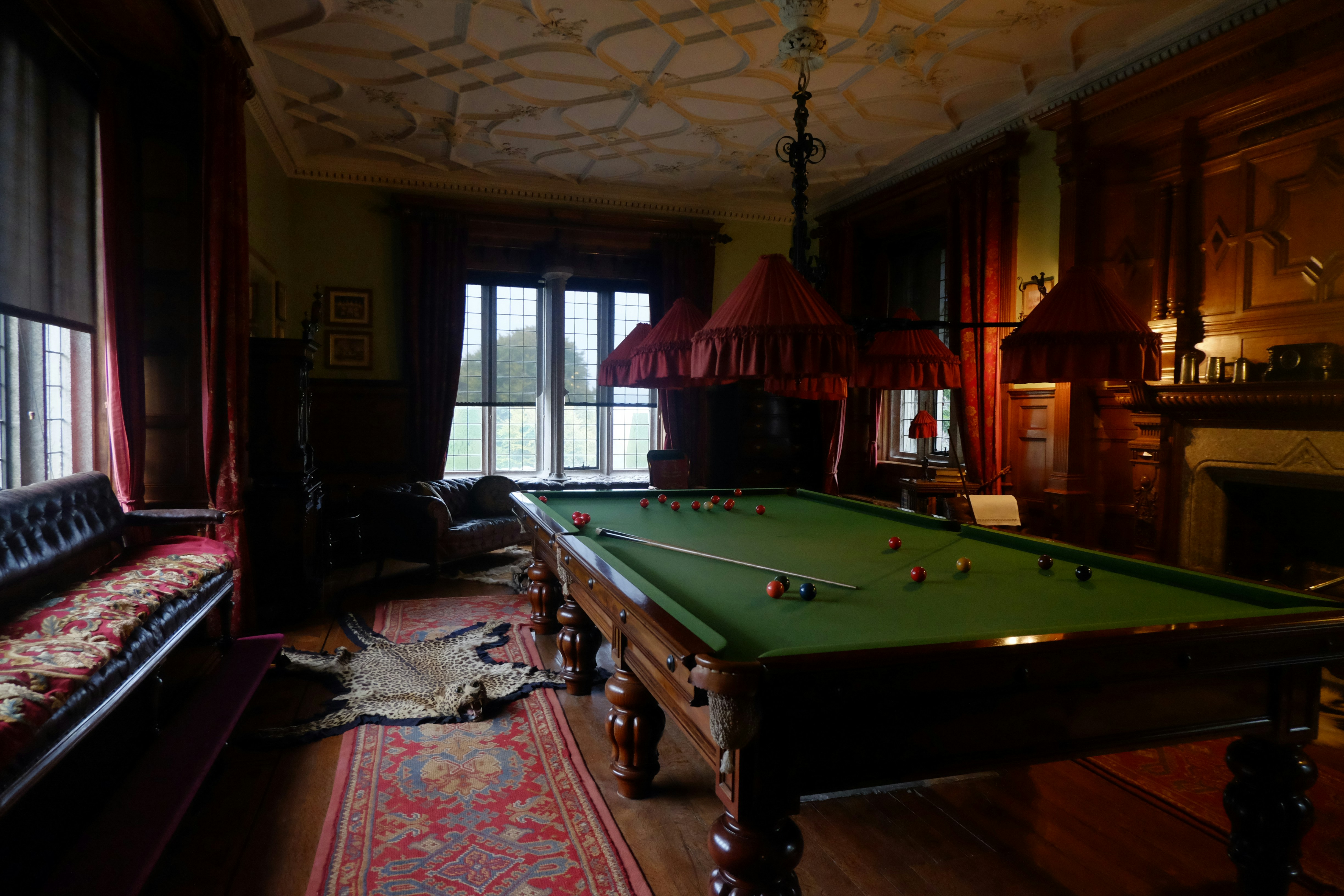 Billiard table in a dimly lit, ornate room.