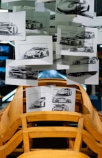 Car design sketches displayed above wooden car frame