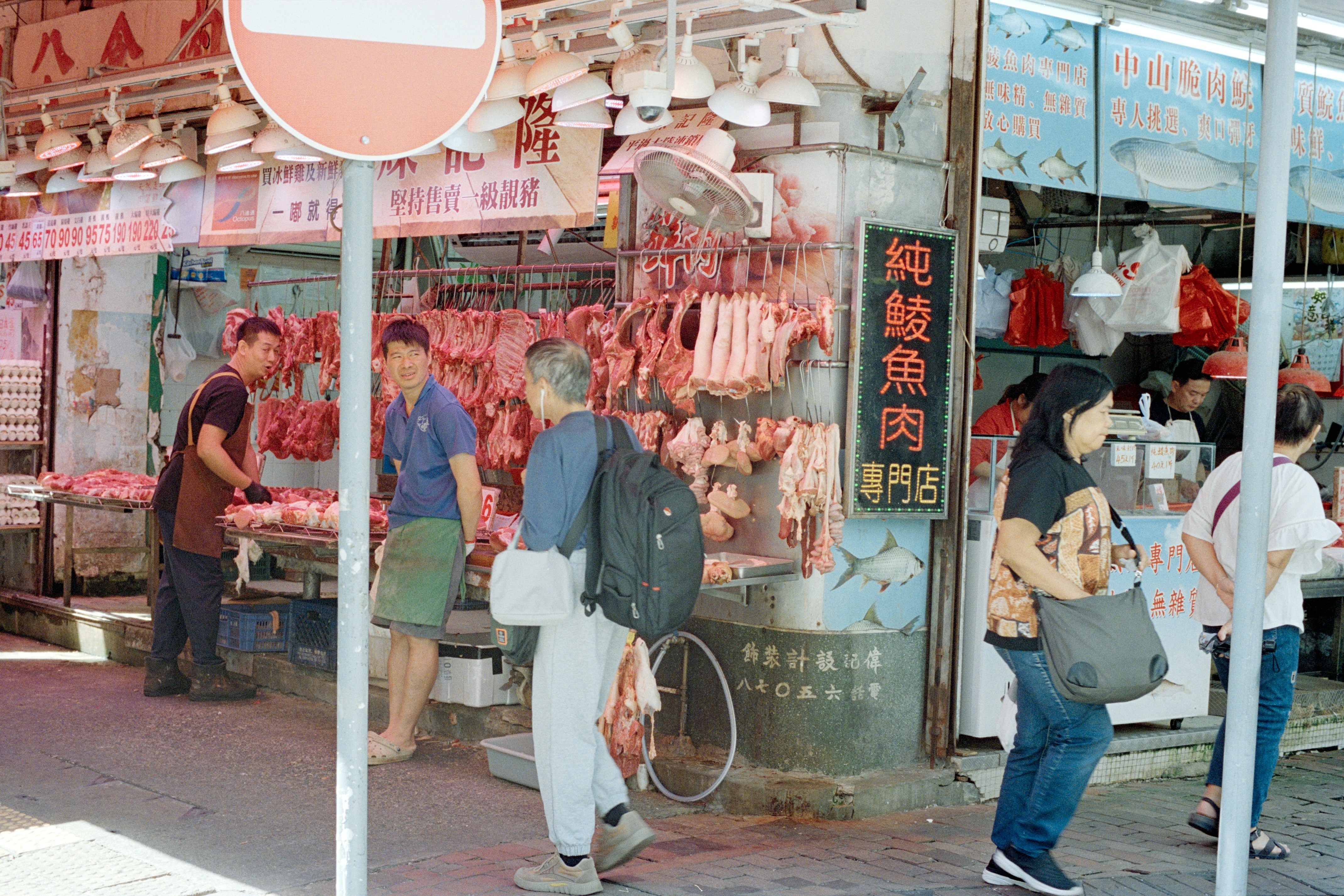 Butcher shop with hanging meats and customers