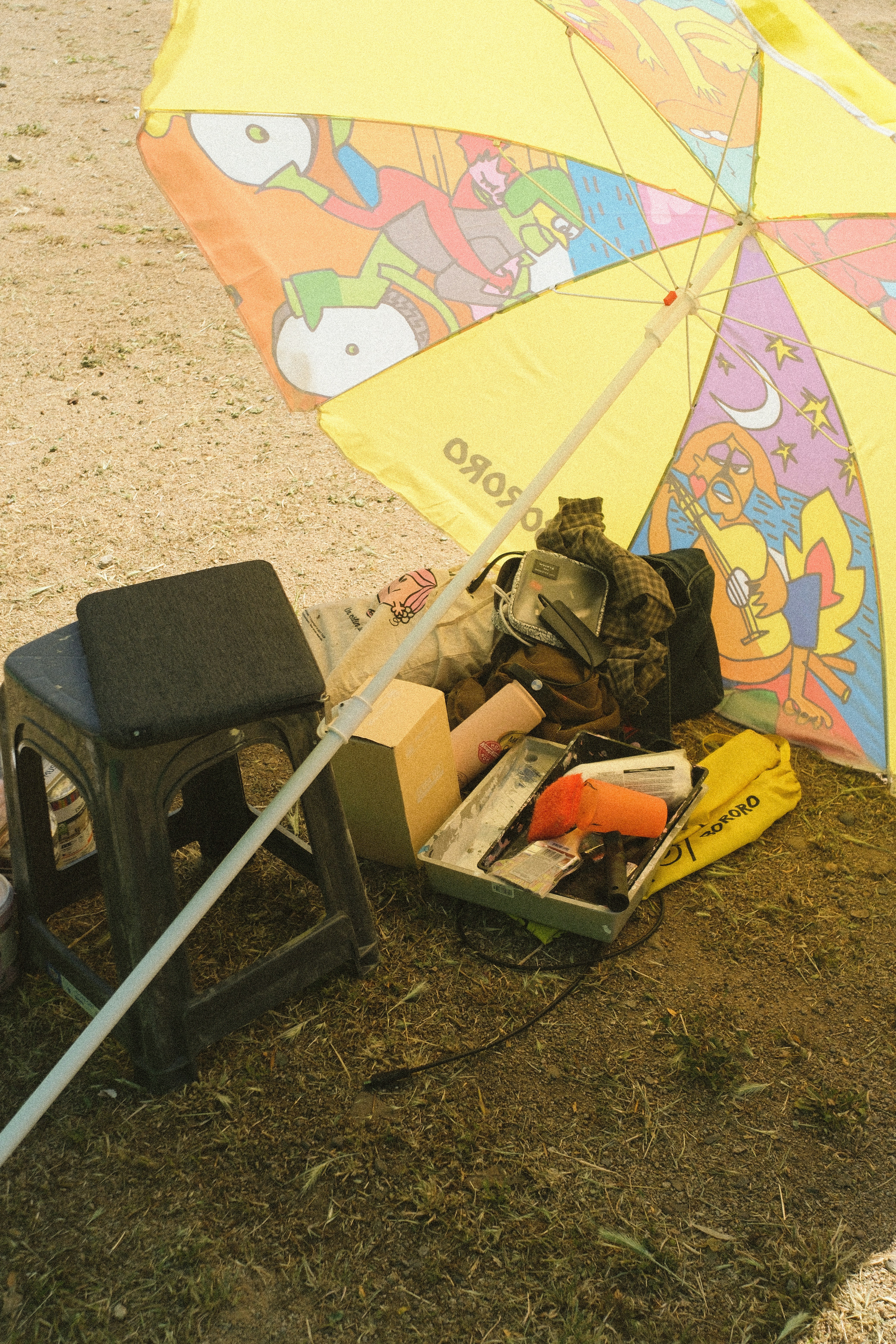 Beach umbrella with assorted items on the ground