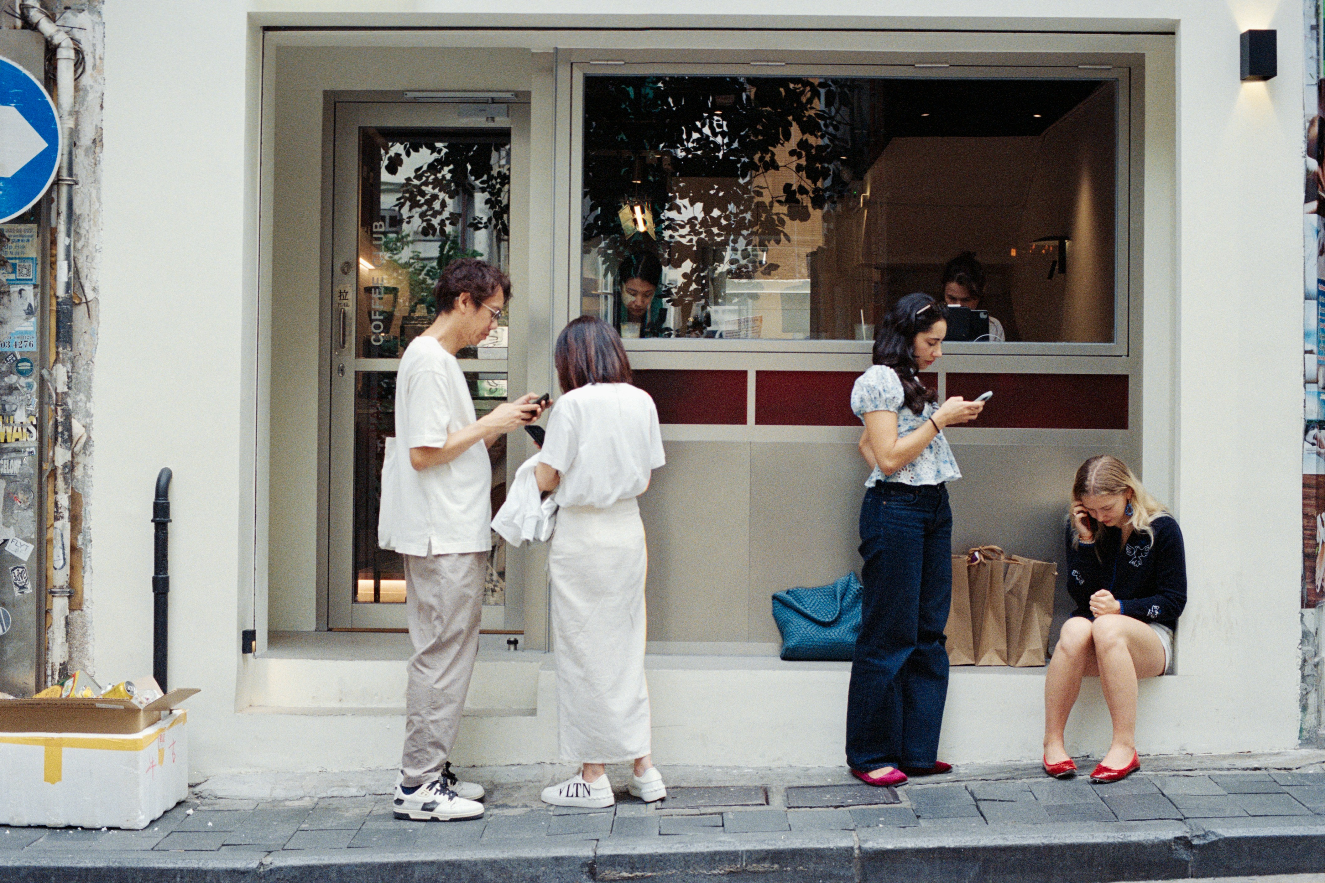 People outside cafe looking at phones