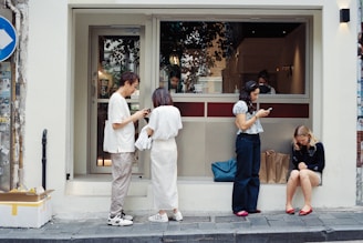 People outside cafe looking at phones