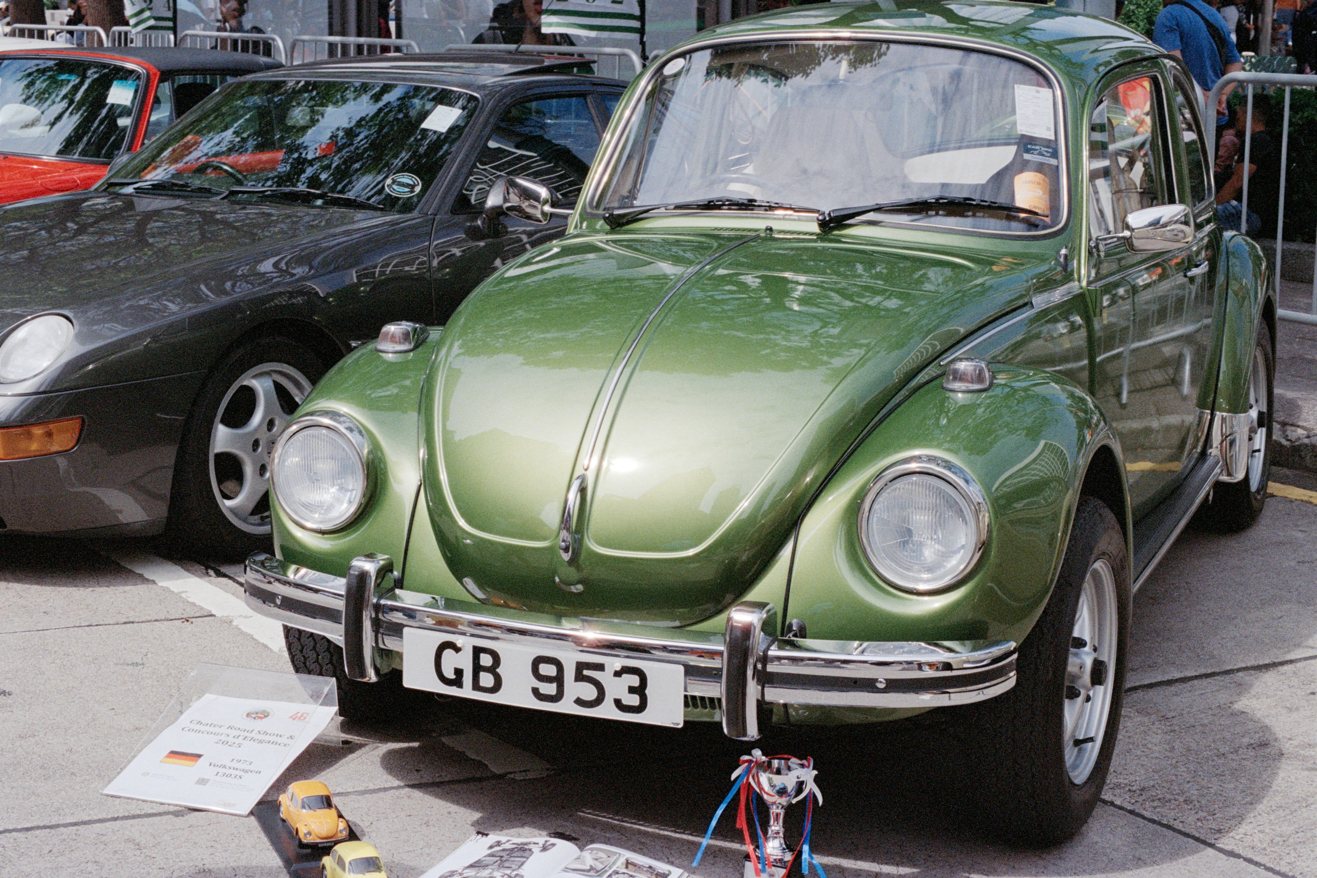 A vintage green volkswagen beetle parked outdoors.