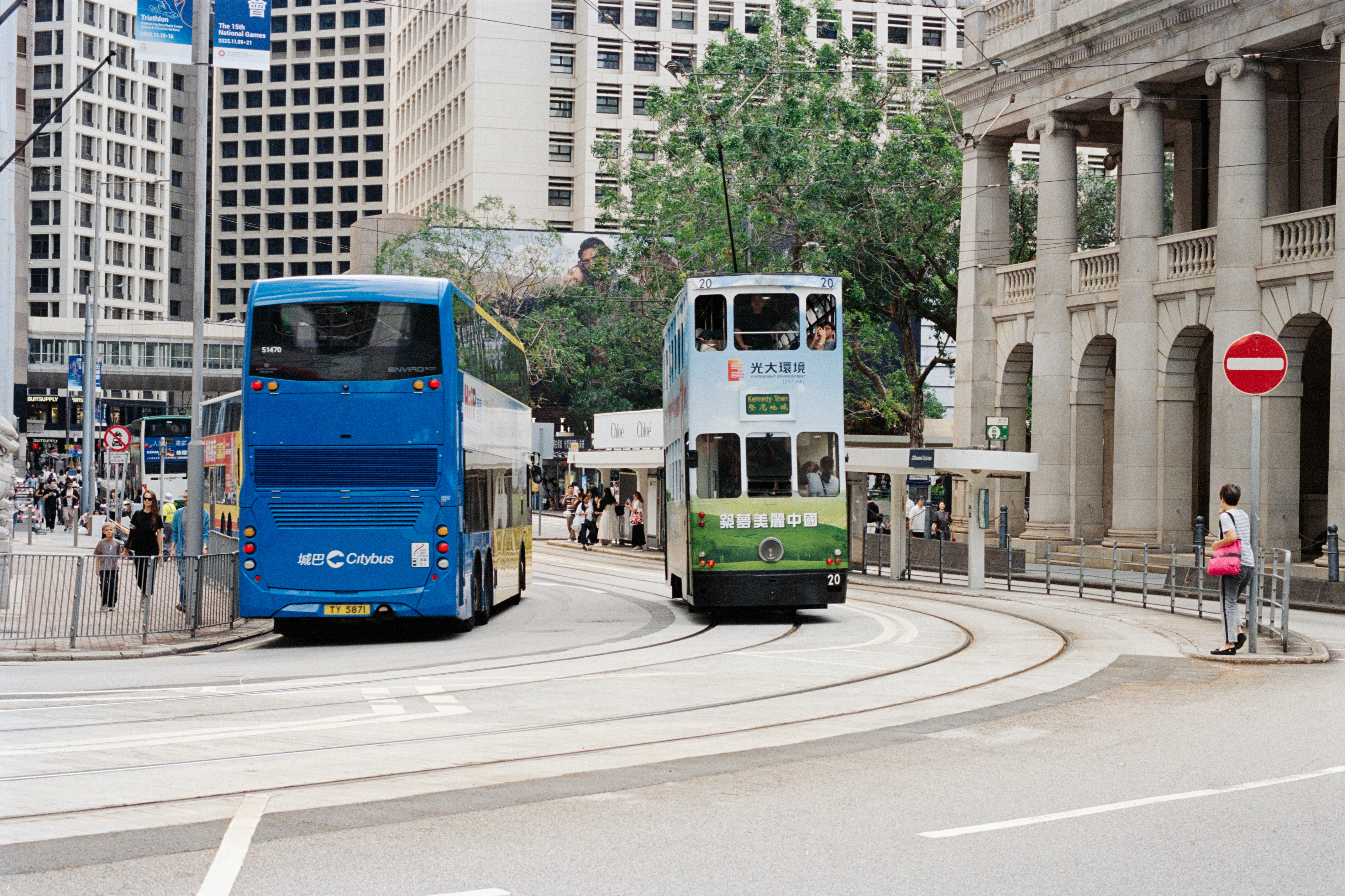 Two buses and a tram on city street