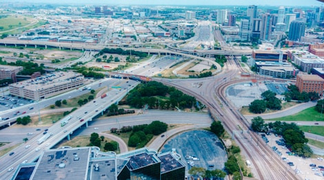 Aerial view of a busy highway interchange and cityscape.