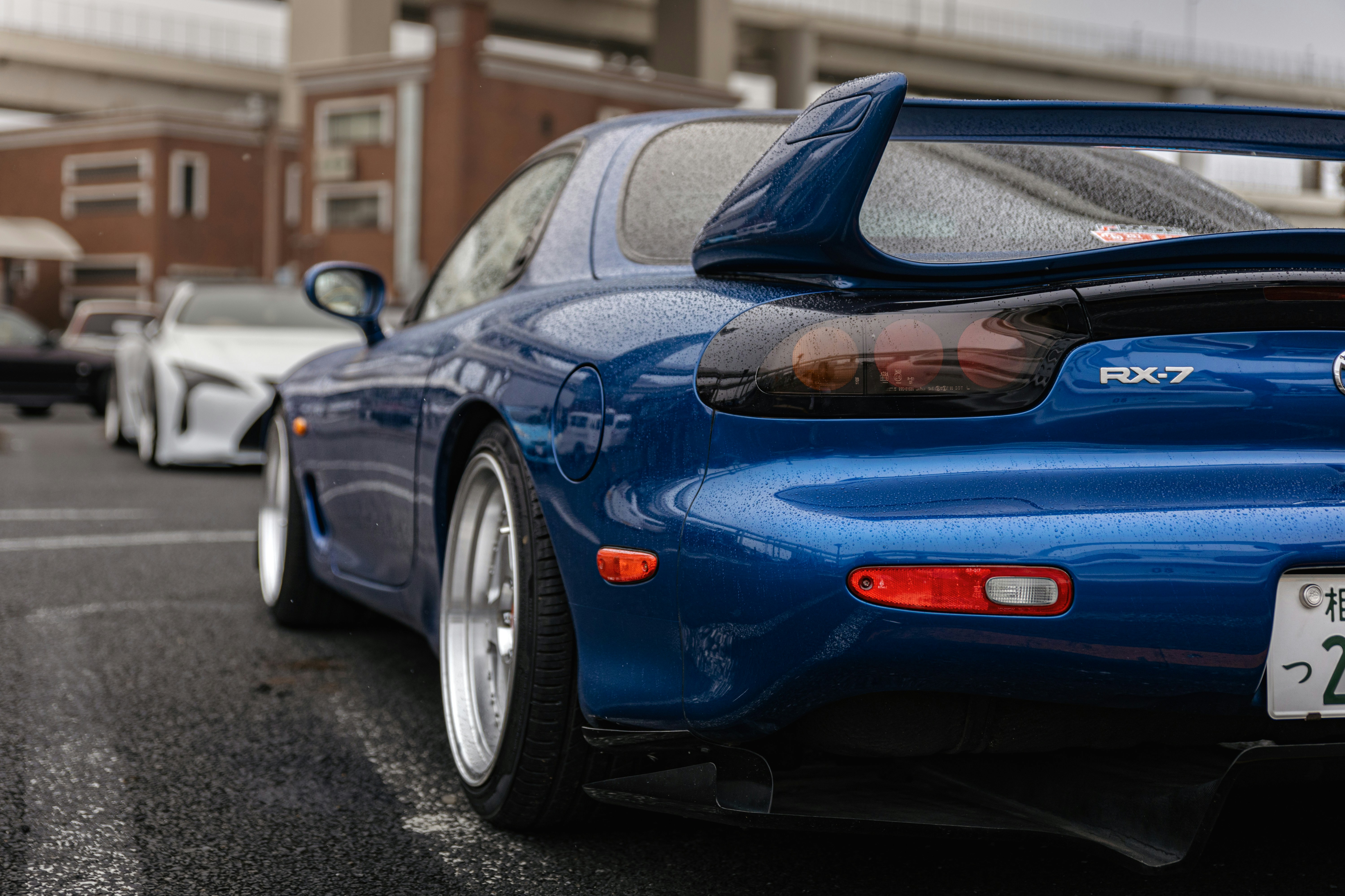 Blue sports car parked on wet asphalt