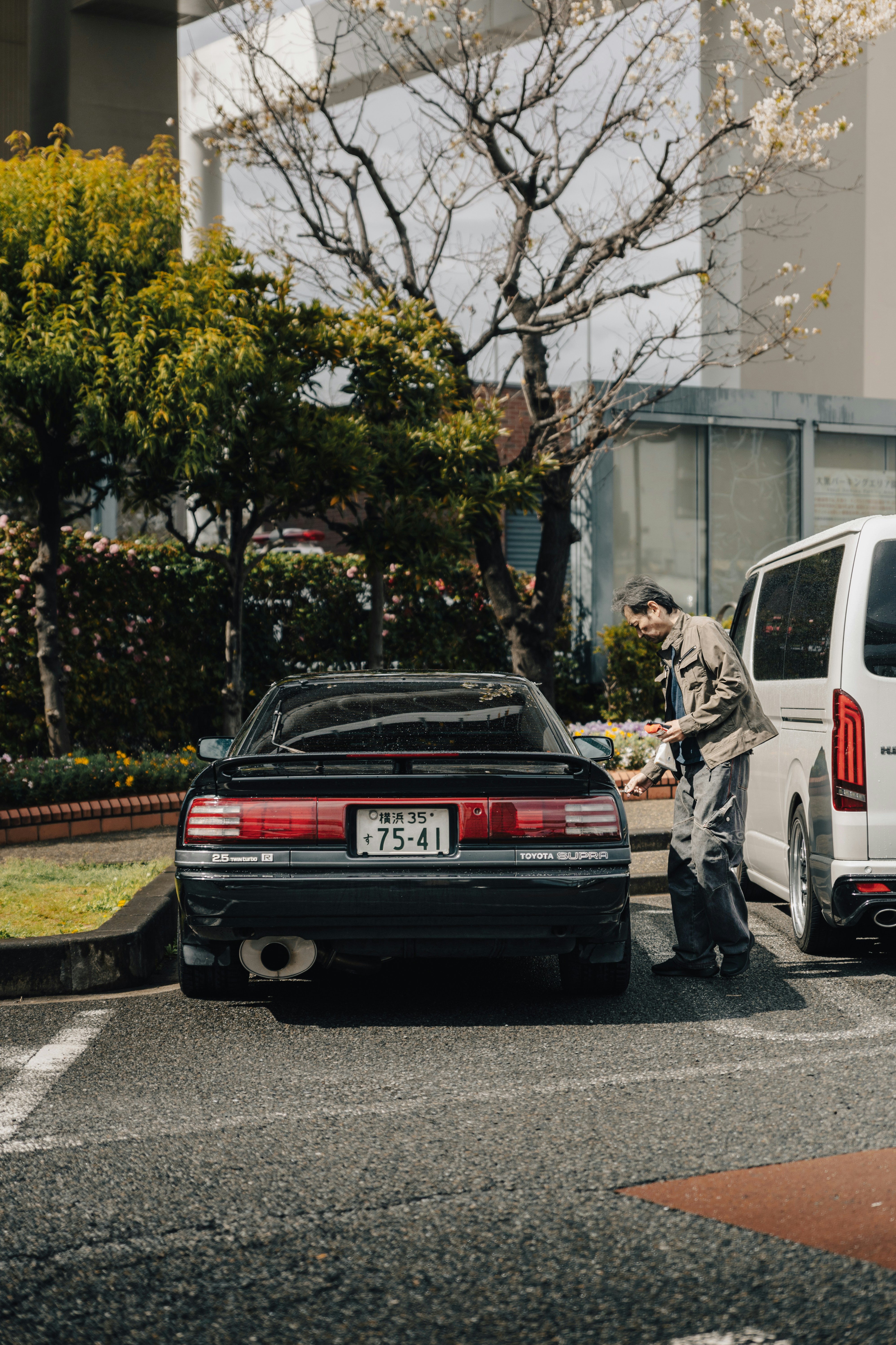Homme appuyé sur une voiture vintage noire