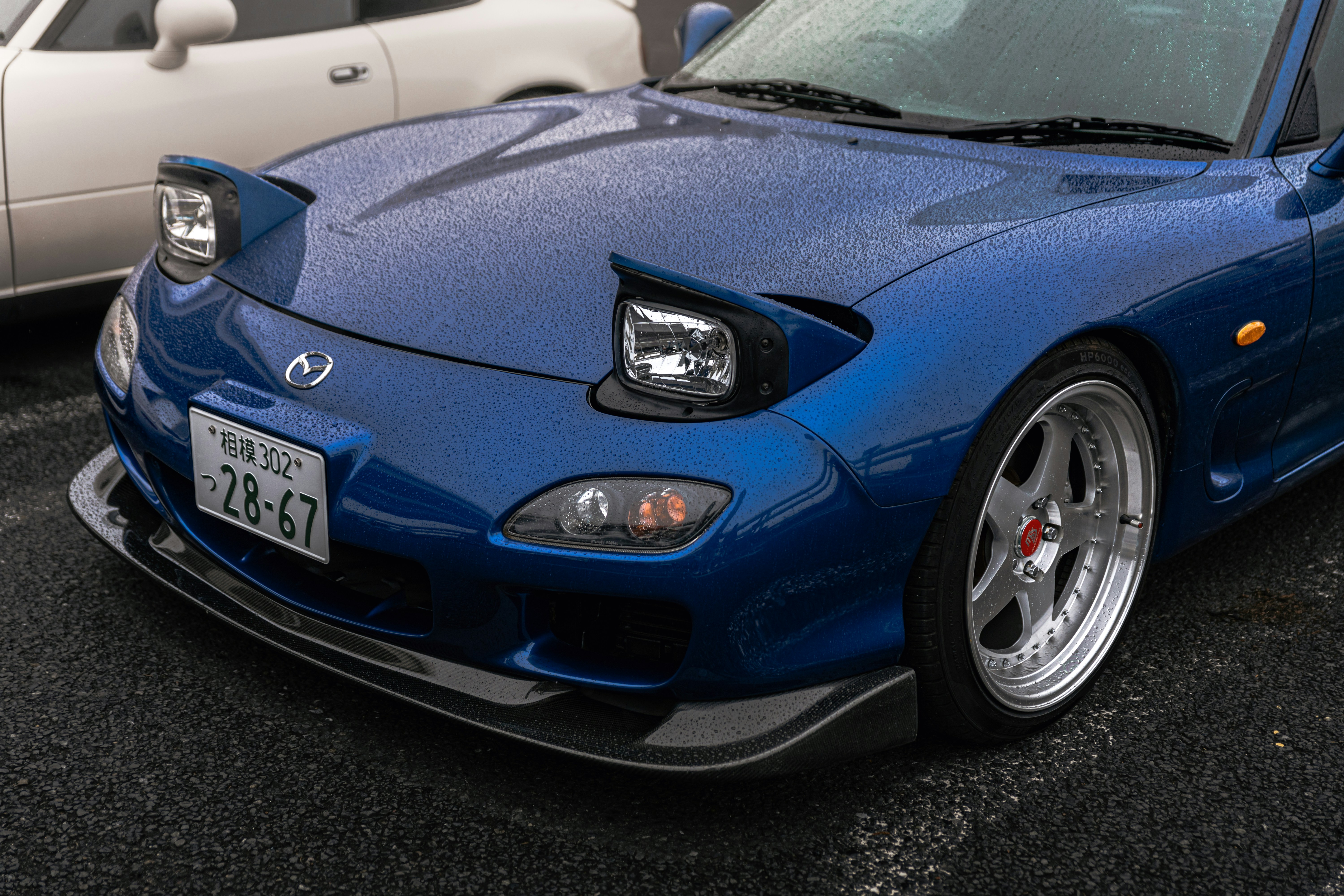 Mobil sport biru dengan lampu depan pop-up