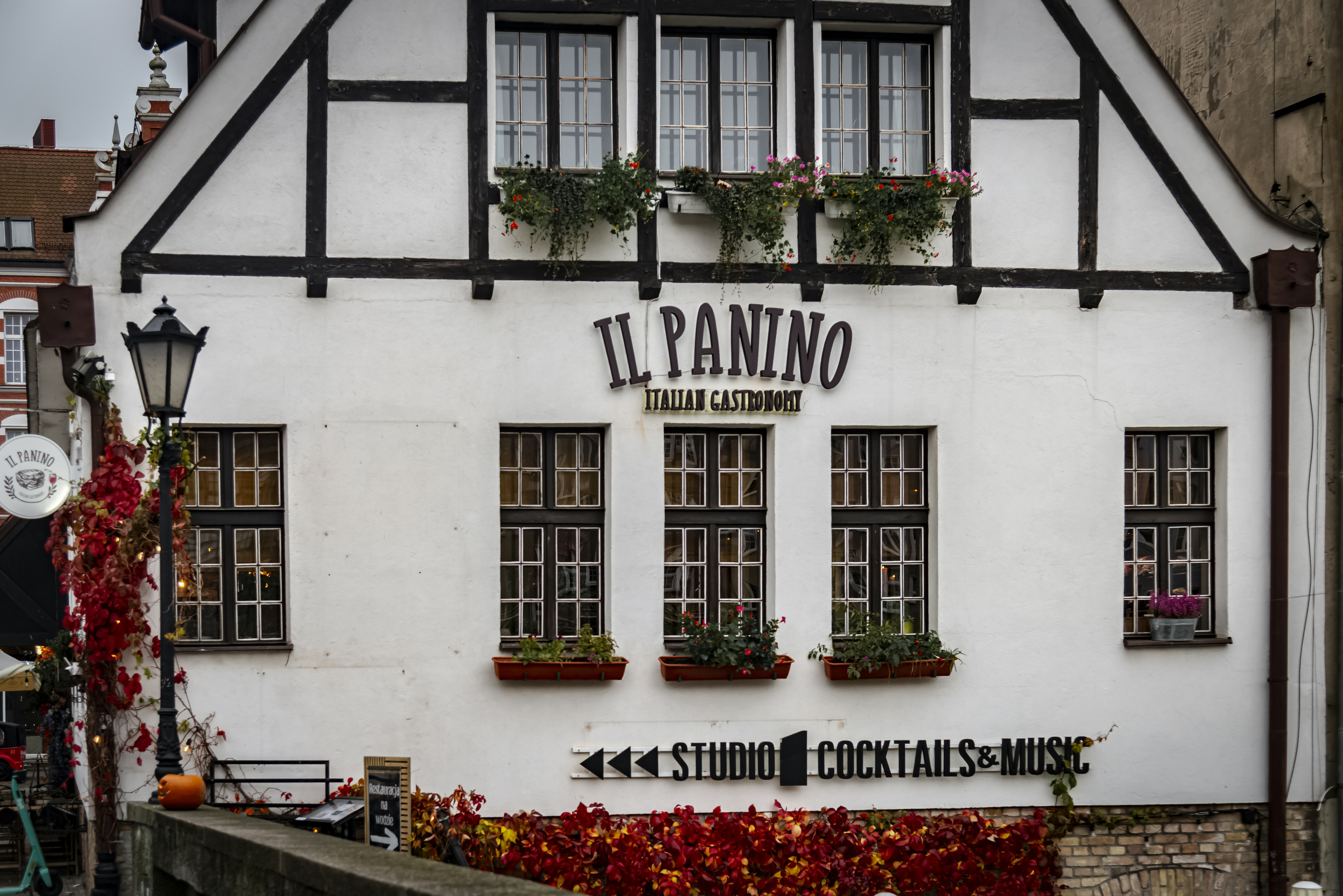 Building with "il panino" sign and autumn foliage