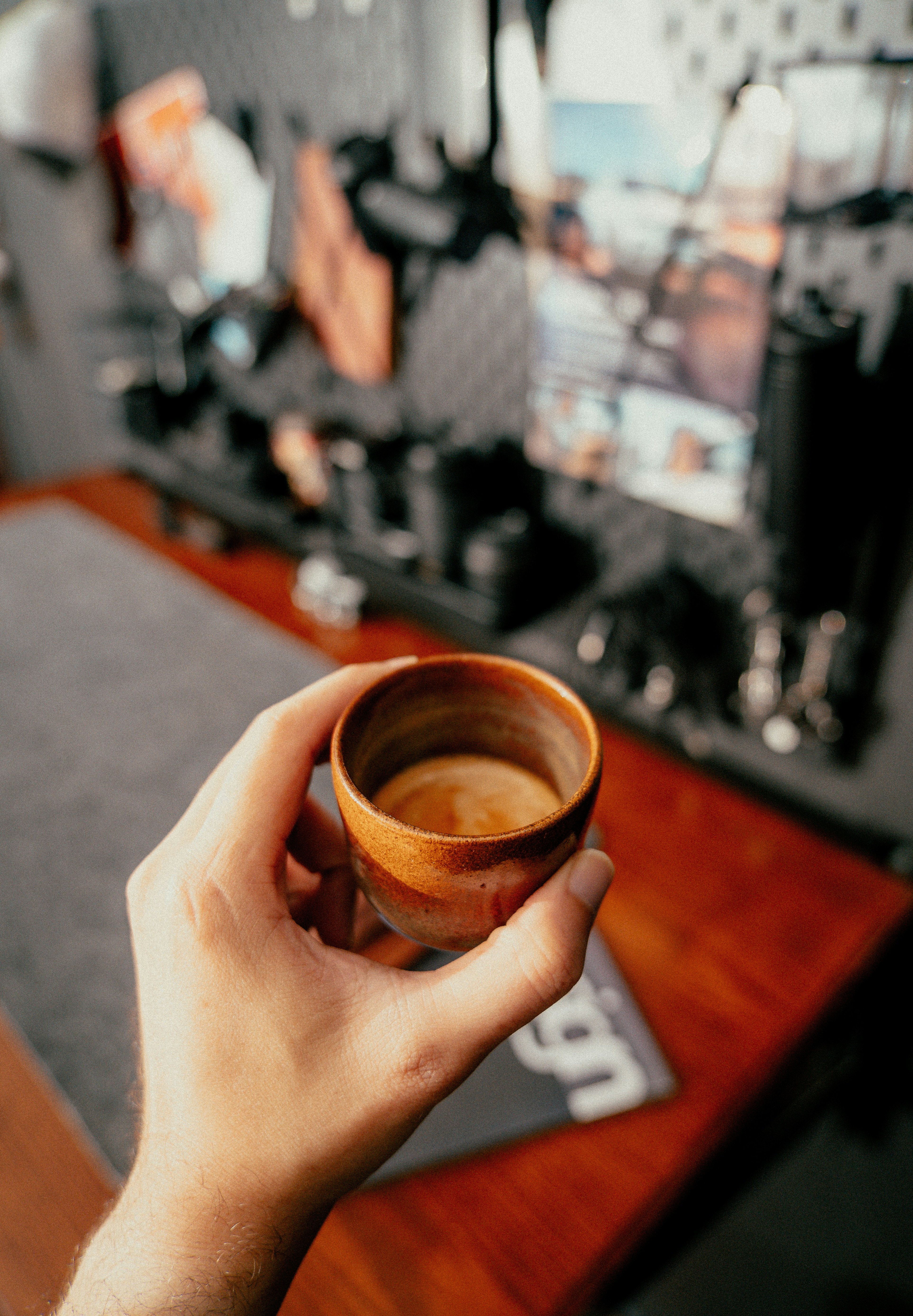 Hand holding a small cup of espresso