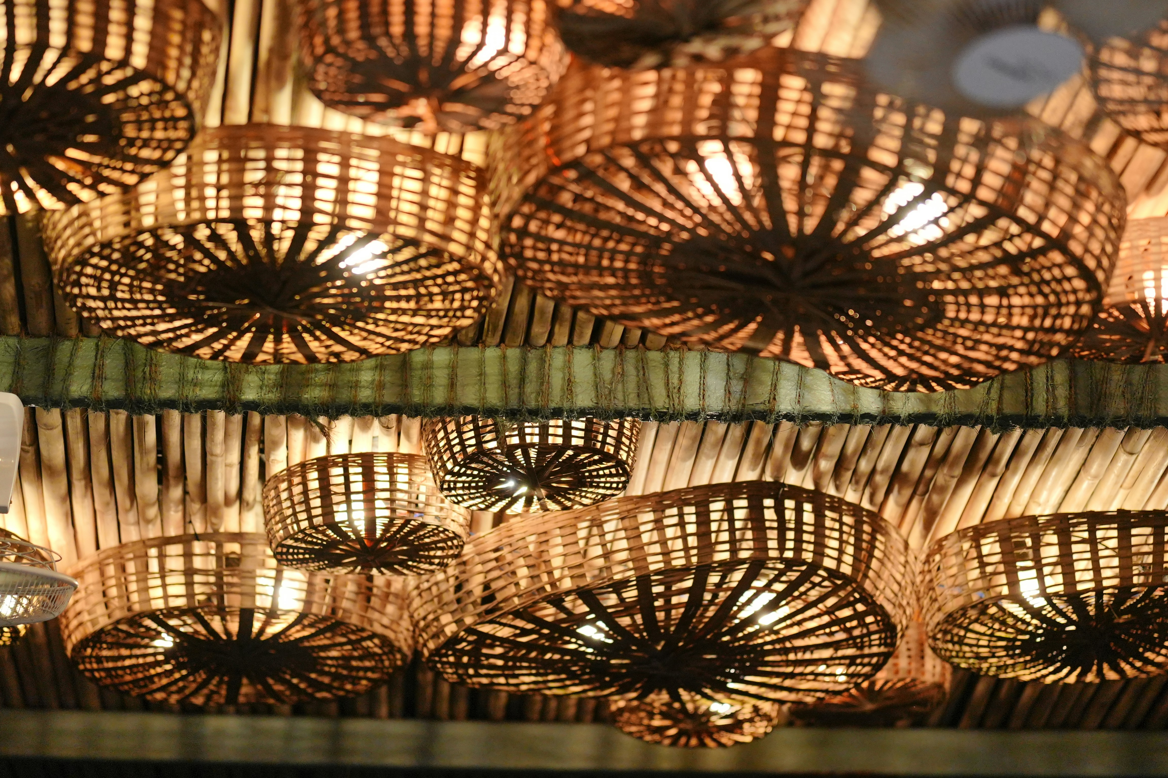 Woven bamboo lamps illuminating a ceiling