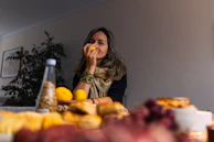 Woman smelling a lemon at a table with food
