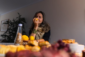 Woman smelling a lemon at a table with food