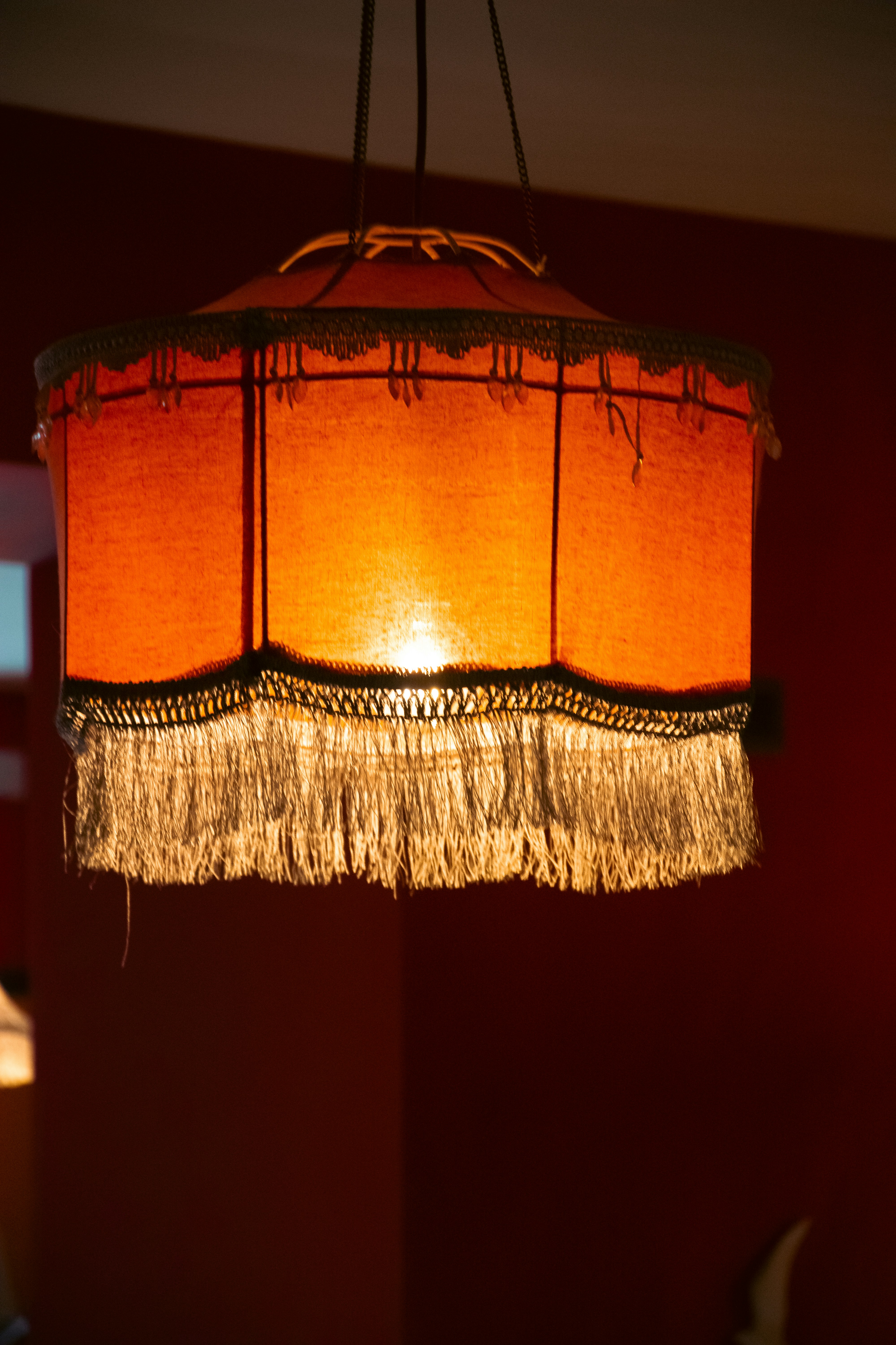 An ornate orange lampshade with fringe detail.