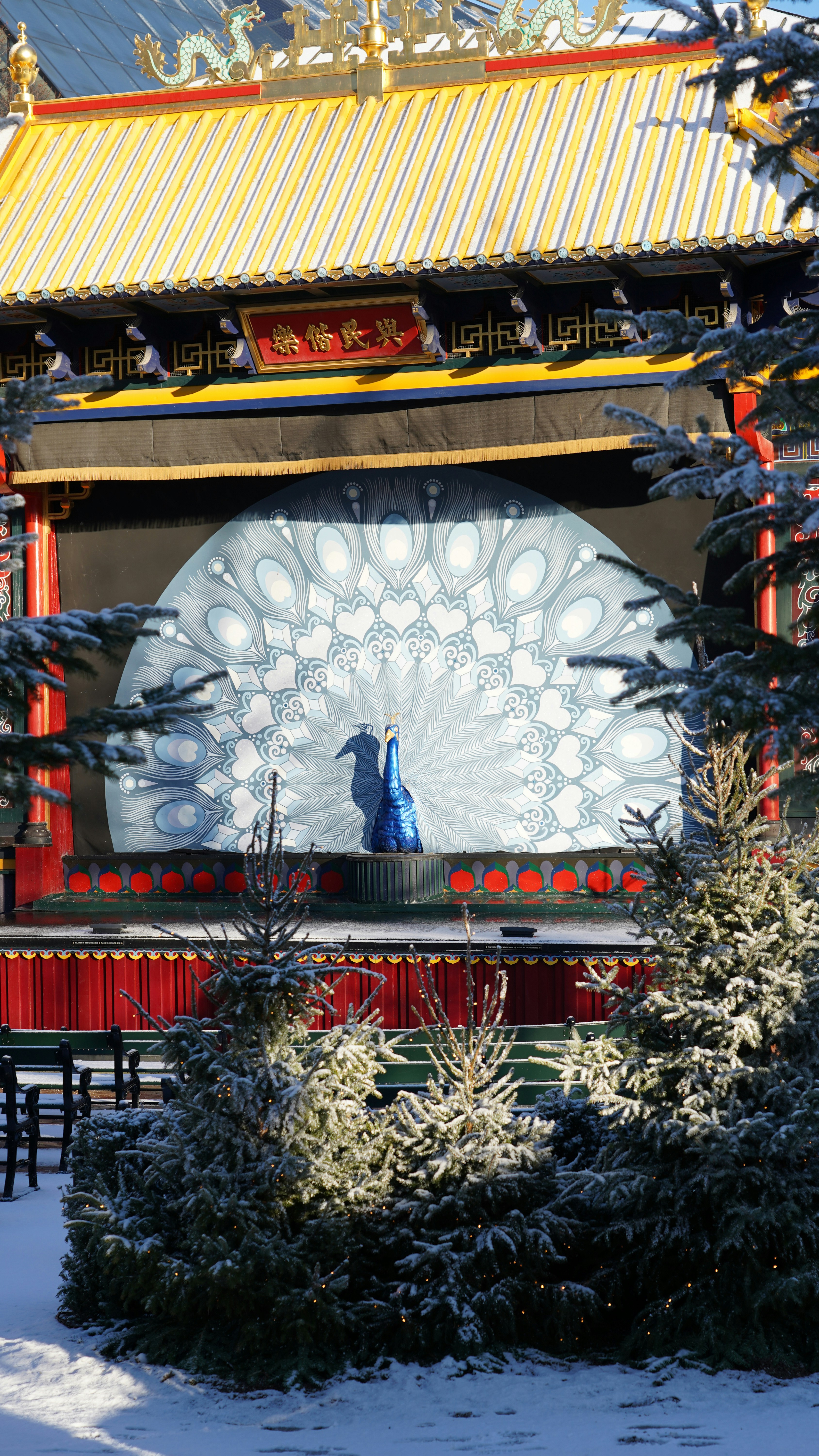 A decorative peacock display in front of a stage