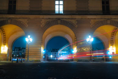 Arched building facade with light trails at night