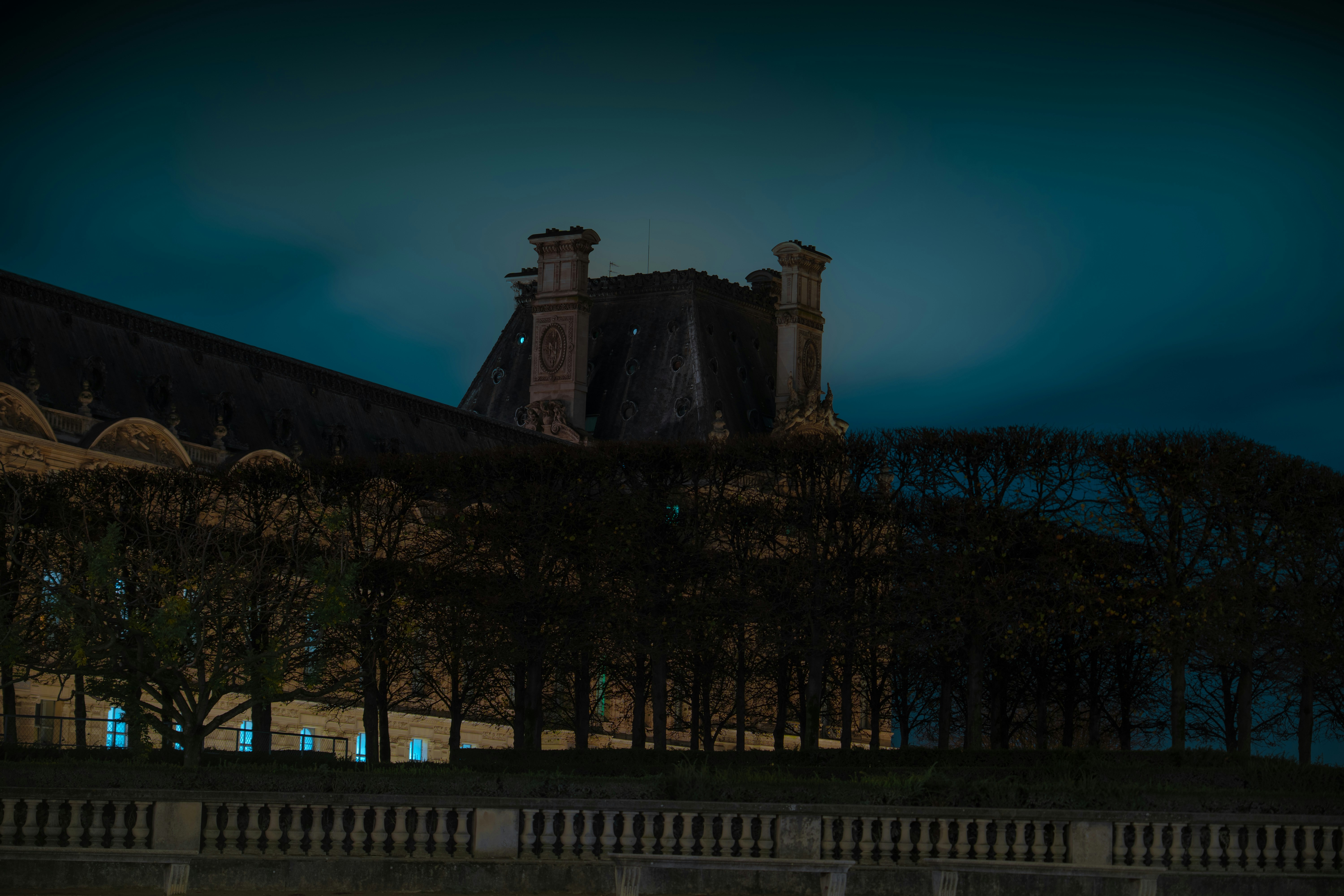 Dark building with ornate rooftop at night.