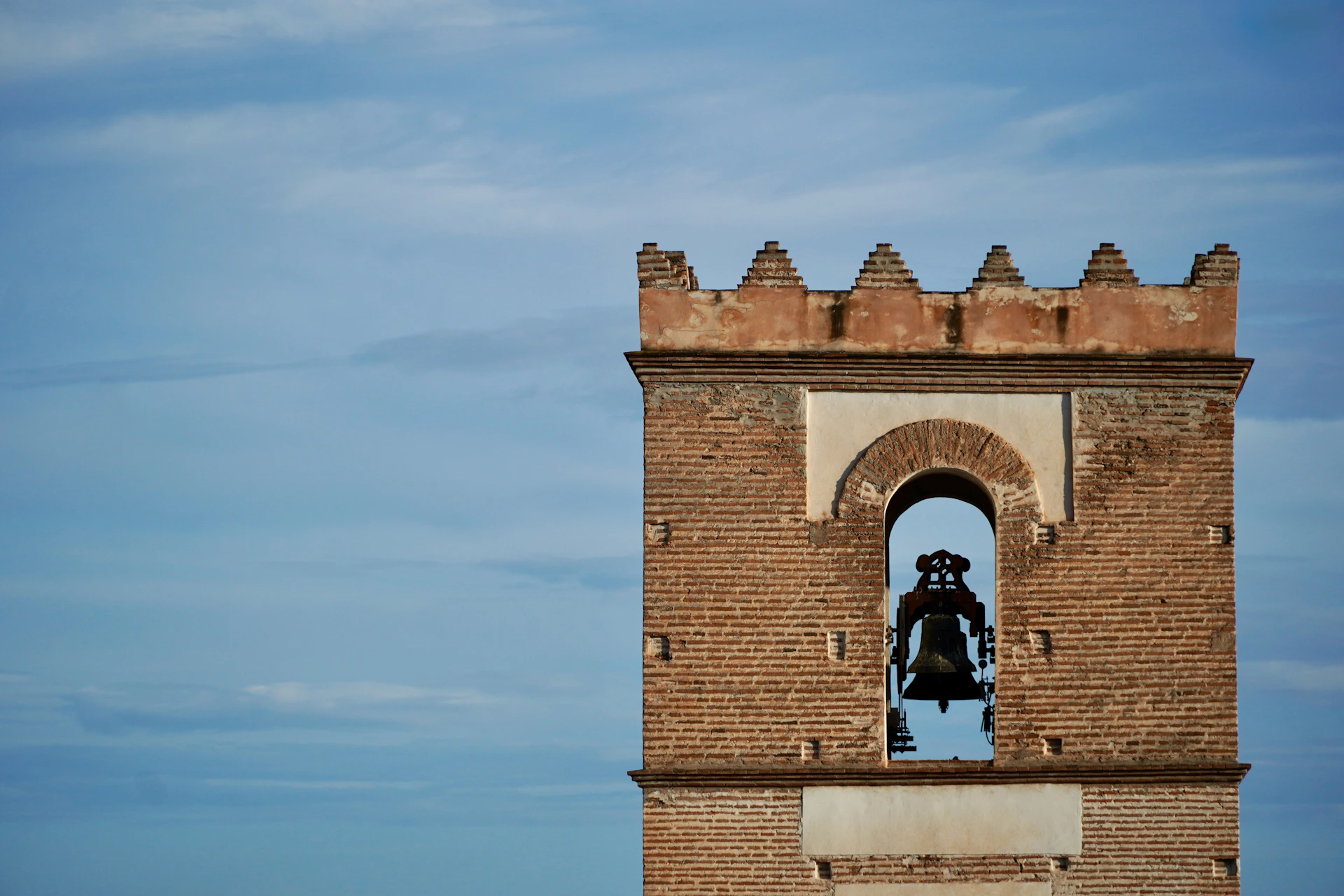 Bell tower with a bell against a blue sky