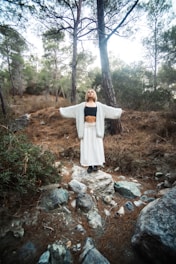 Woman with arms outstretched in a forest