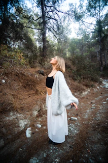 Woman with arms outstretched in a forest
