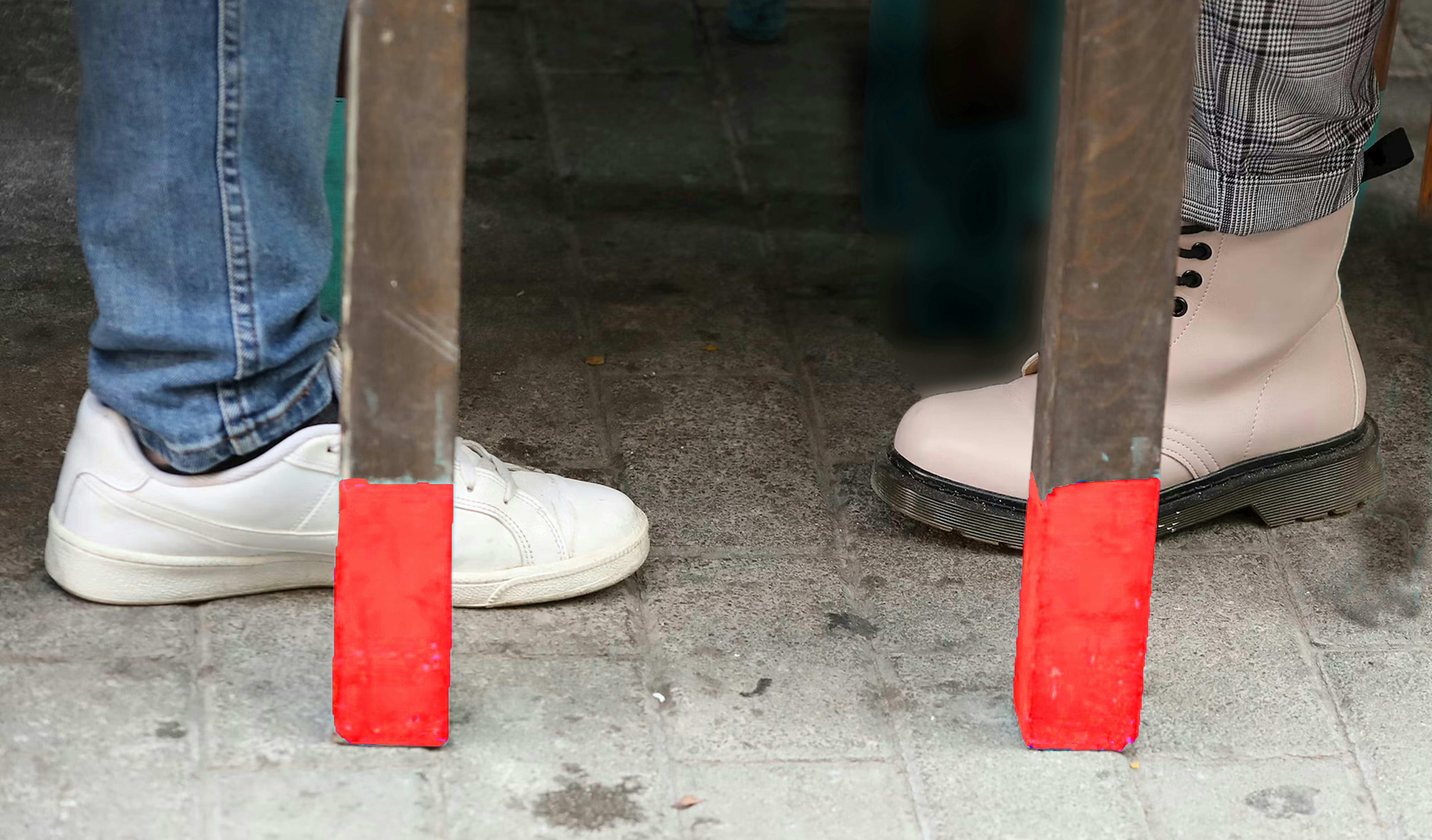 Two people stand on a concrete surface.