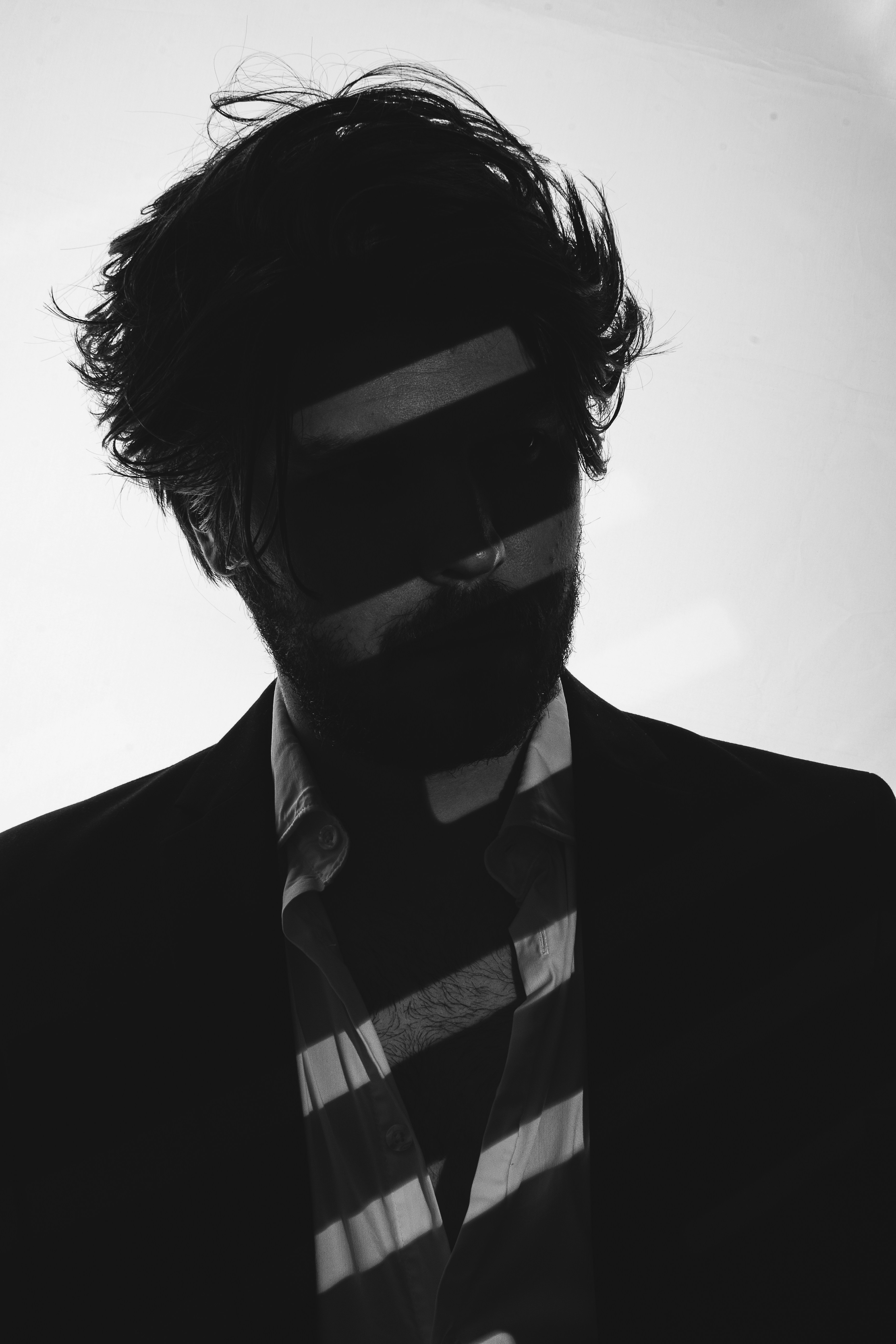 Man in suit with striped shadows across face