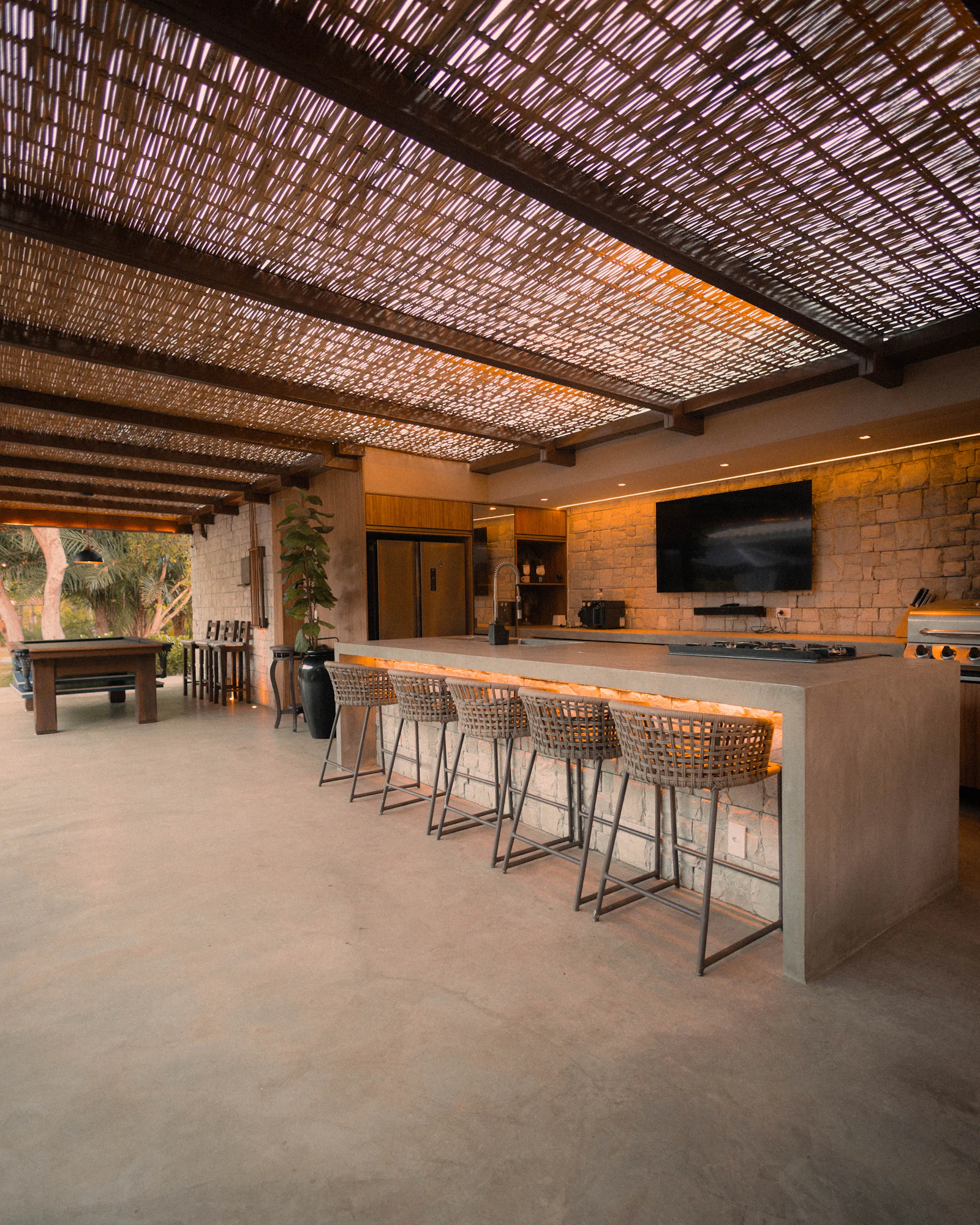 A modern outdoor kitchen with an island and bar stools