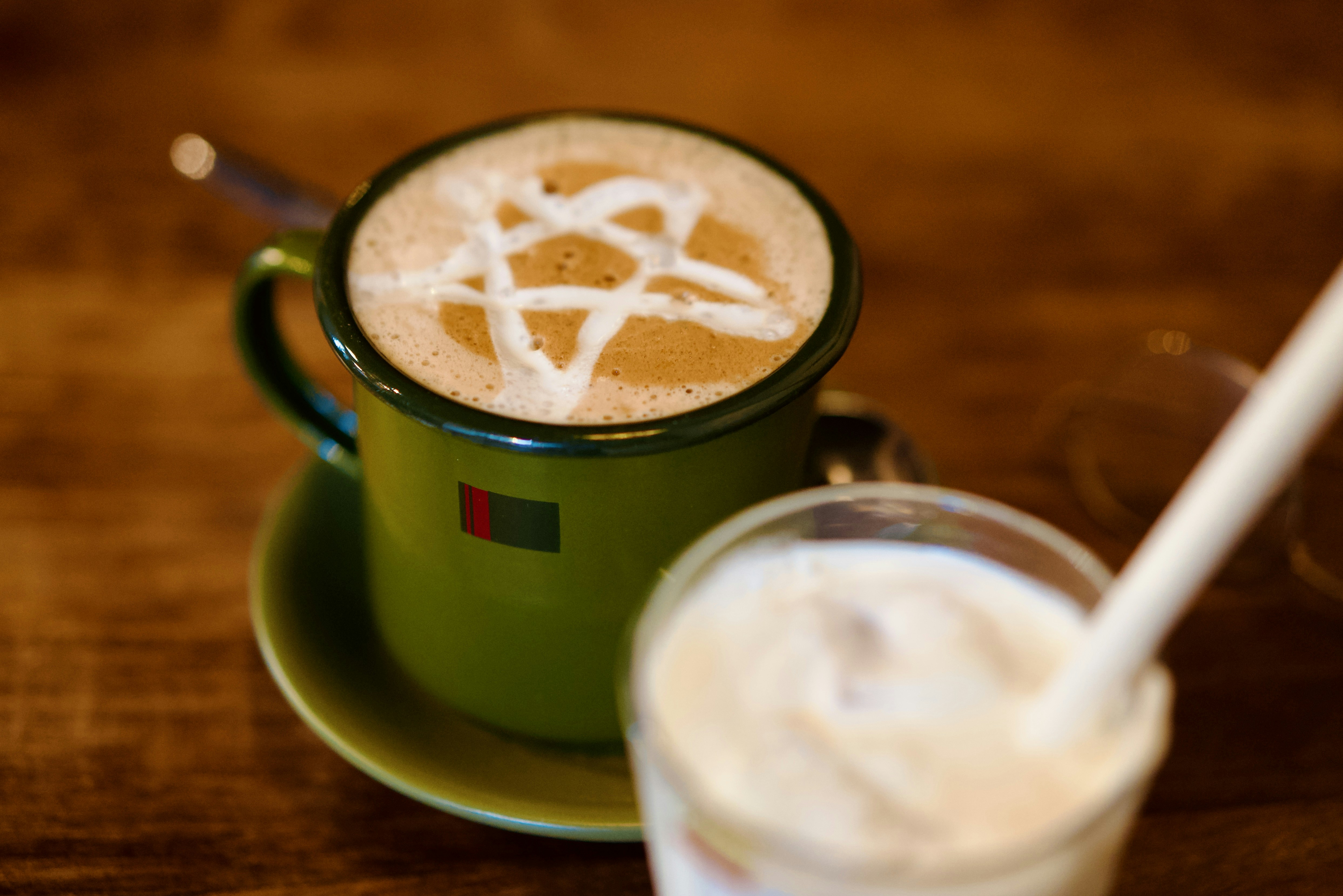 Two drinks with latte art on a table