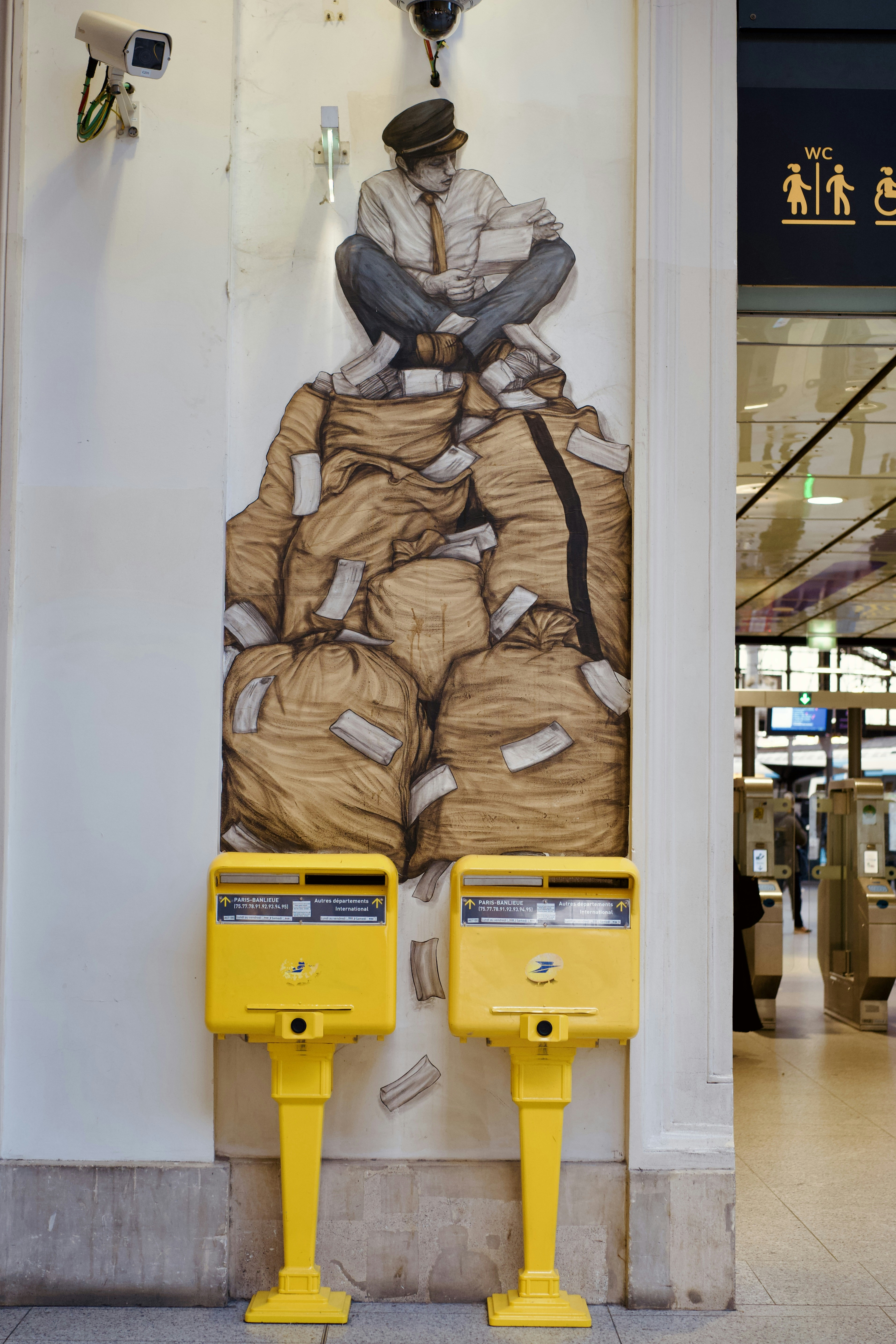 Man sits on pile of money bags with mailboxes