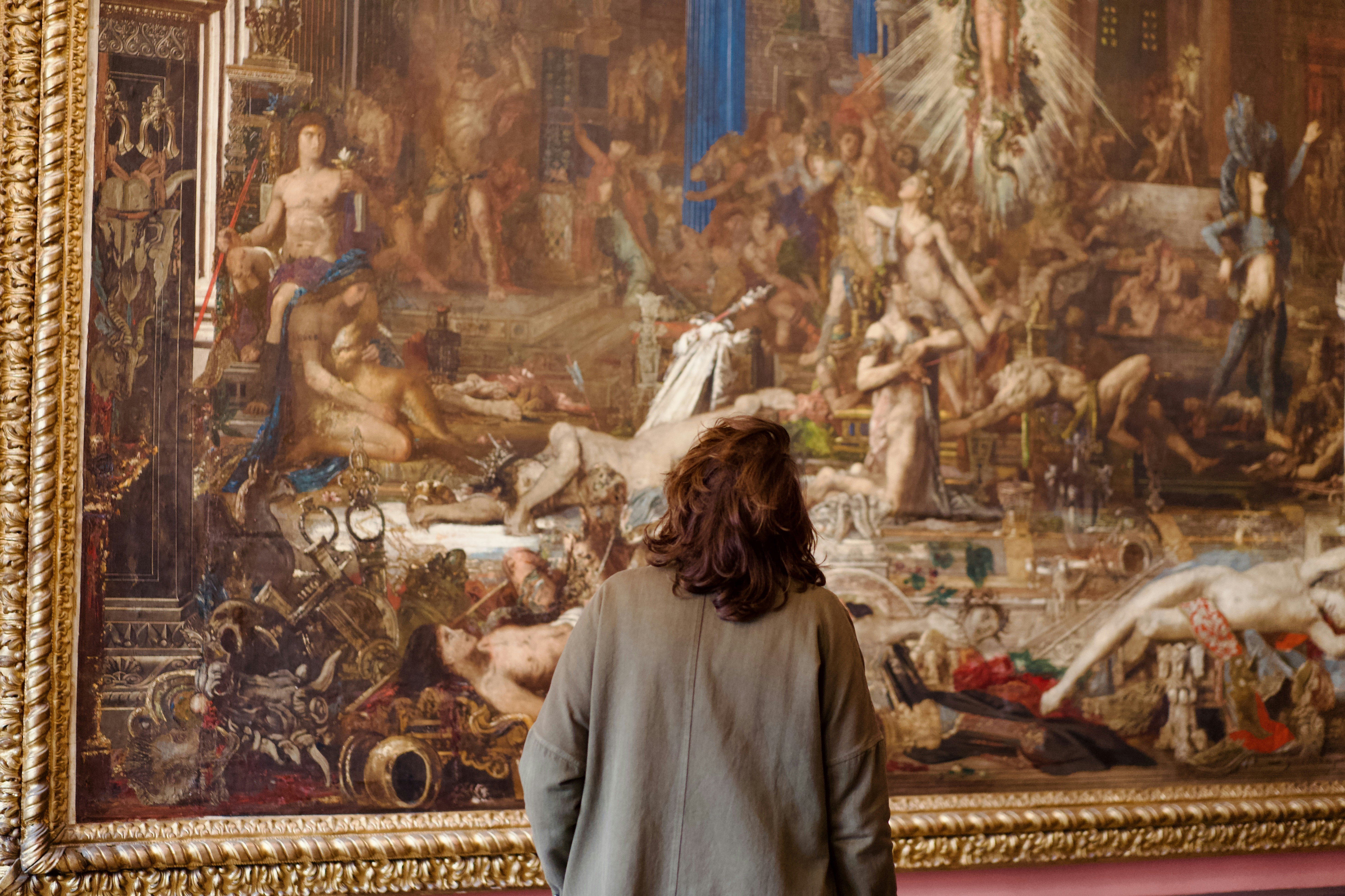 Woman looking at a large, detailed painting
