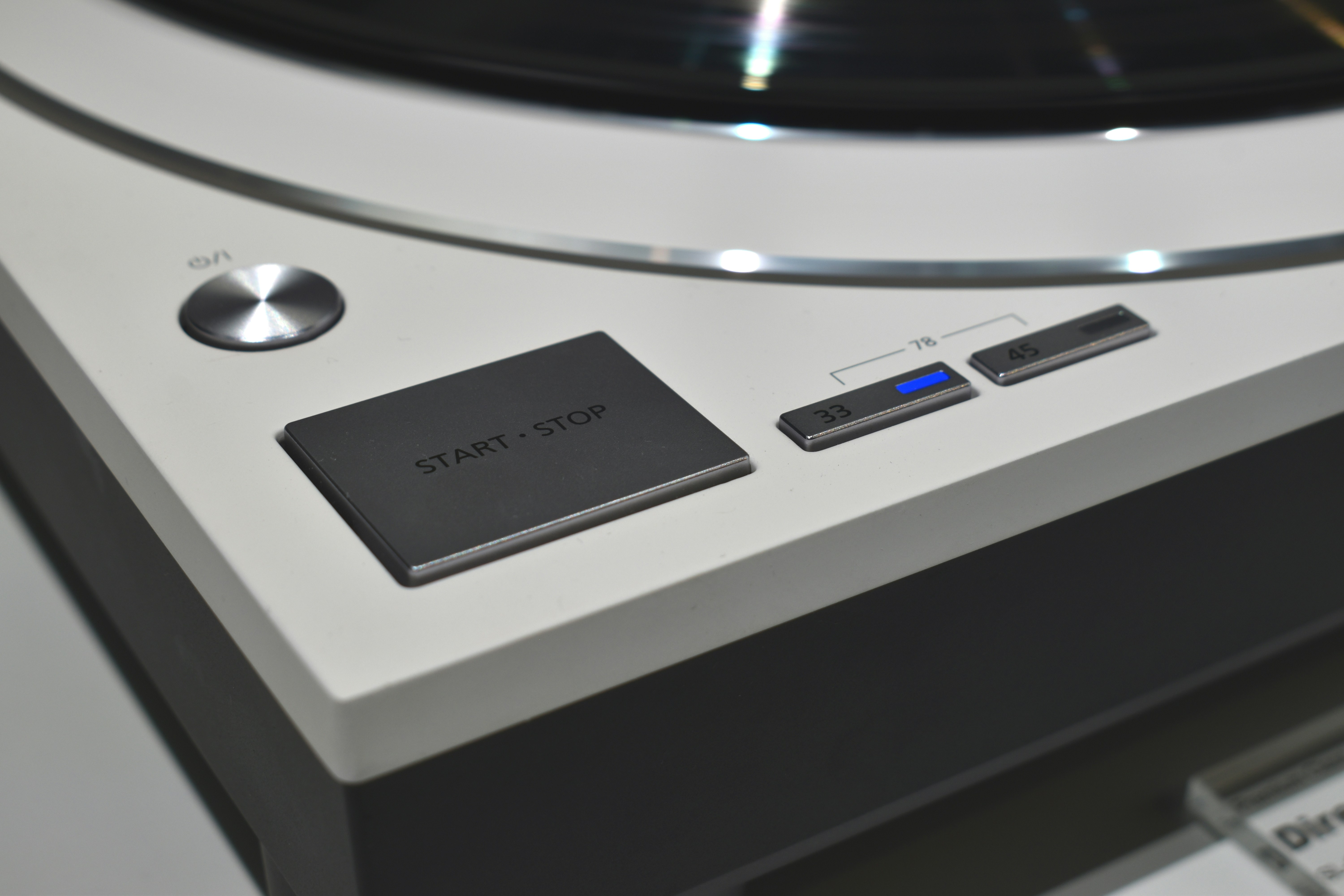Nahaufnahme des Start-Stopp-Knopfes eines Plattenspielers.