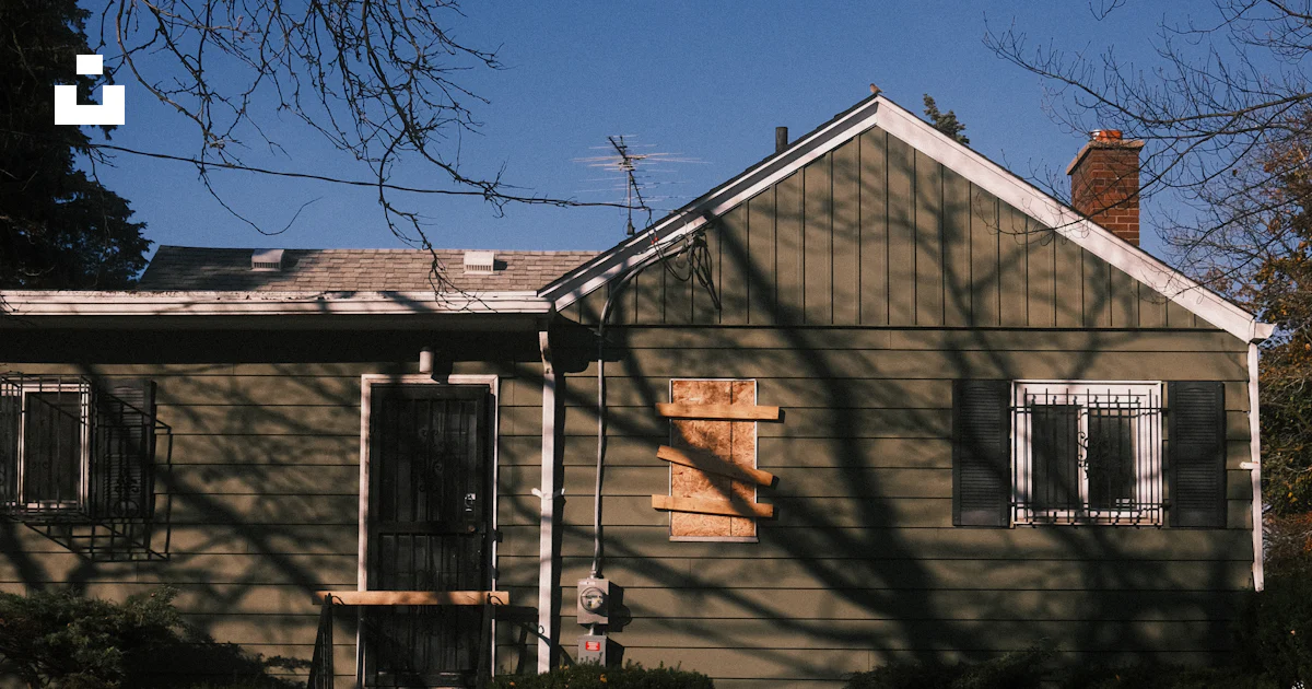 A weathered green house with boarded window. photo – Free House Image ...