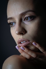 A woman's face with hand touching her chin