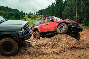 Two off-road vehicles navigating a muddy trail.