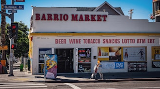 Barrio market store with beer, wine, tobacco, snacks signs.