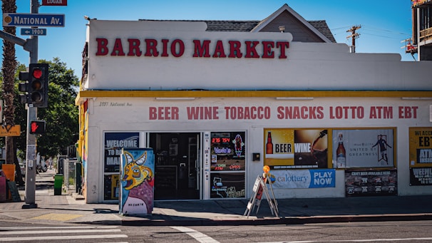 Barrio market store with beer, wine, tobacco, snacks signs.