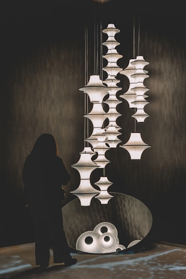 Woman looking at a modern art installation with lamps.