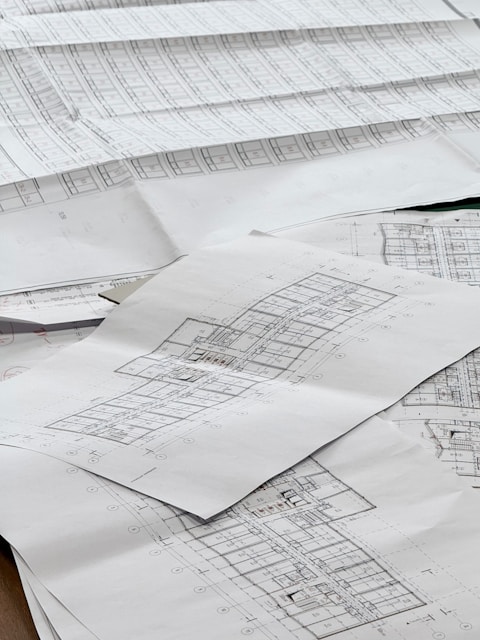 Architectural blueprints spread out on a surface.