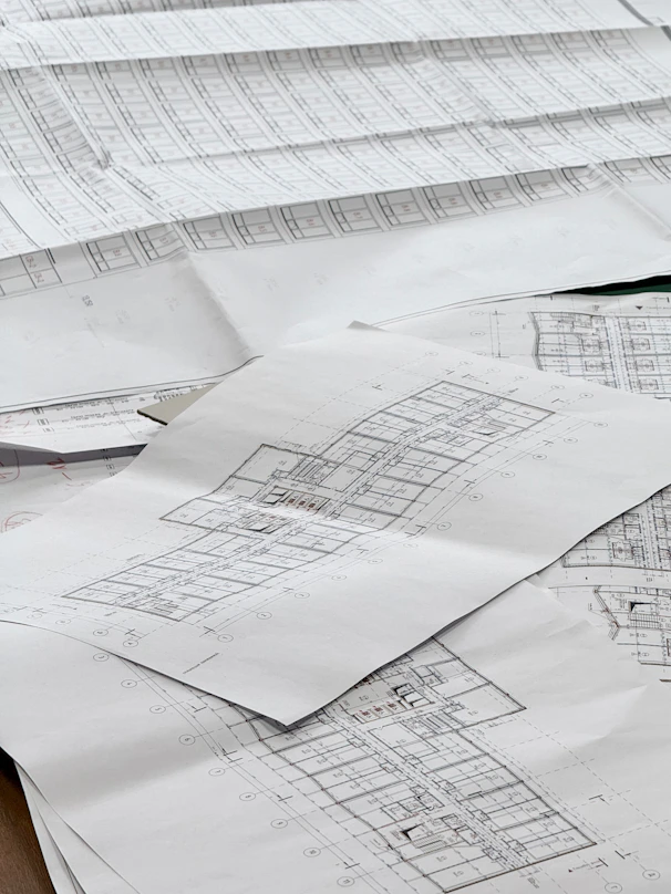 Architectural blueprints spread out on a surface.
