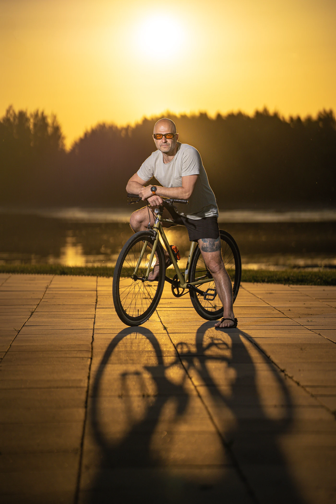 Mature man with bicycle at sunset — endurance regained