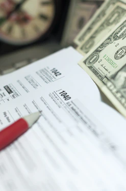 Tax forms with dollars and pencil