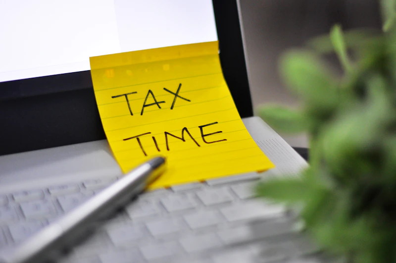 Yellow sticky note with tax time written on it