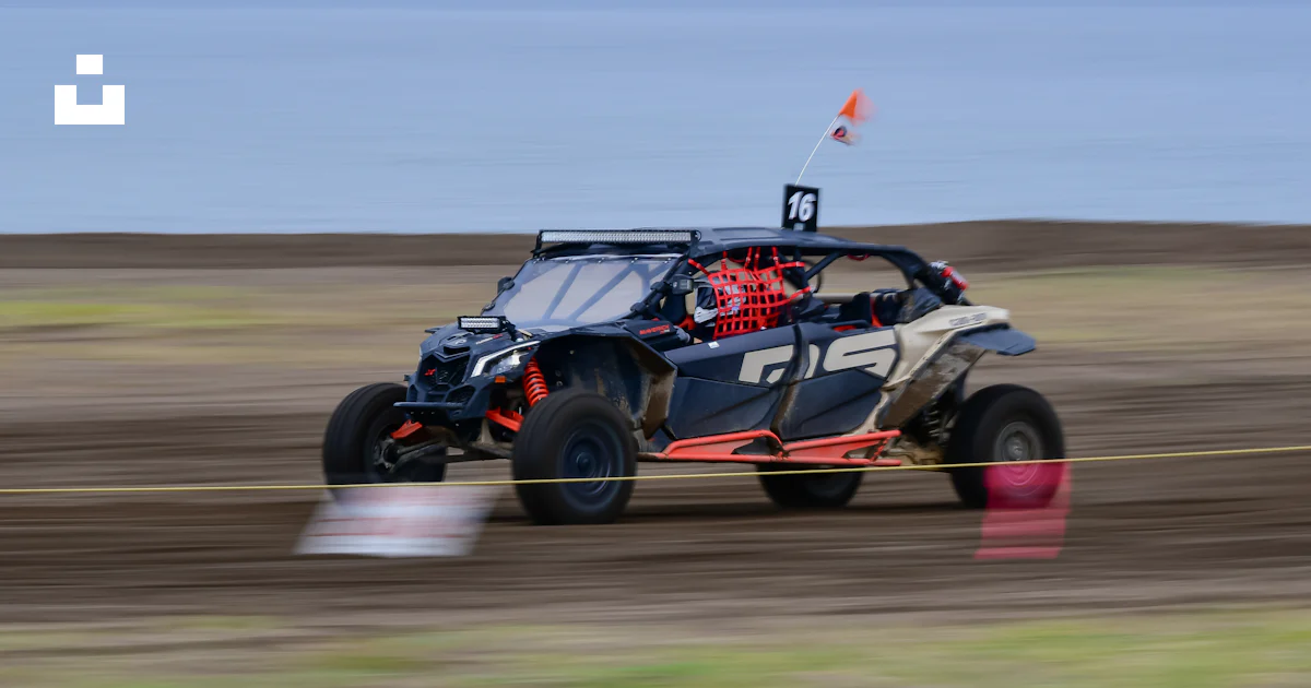 A side-by-side off-road vehicle racing on a dirt track. photo – Free ...