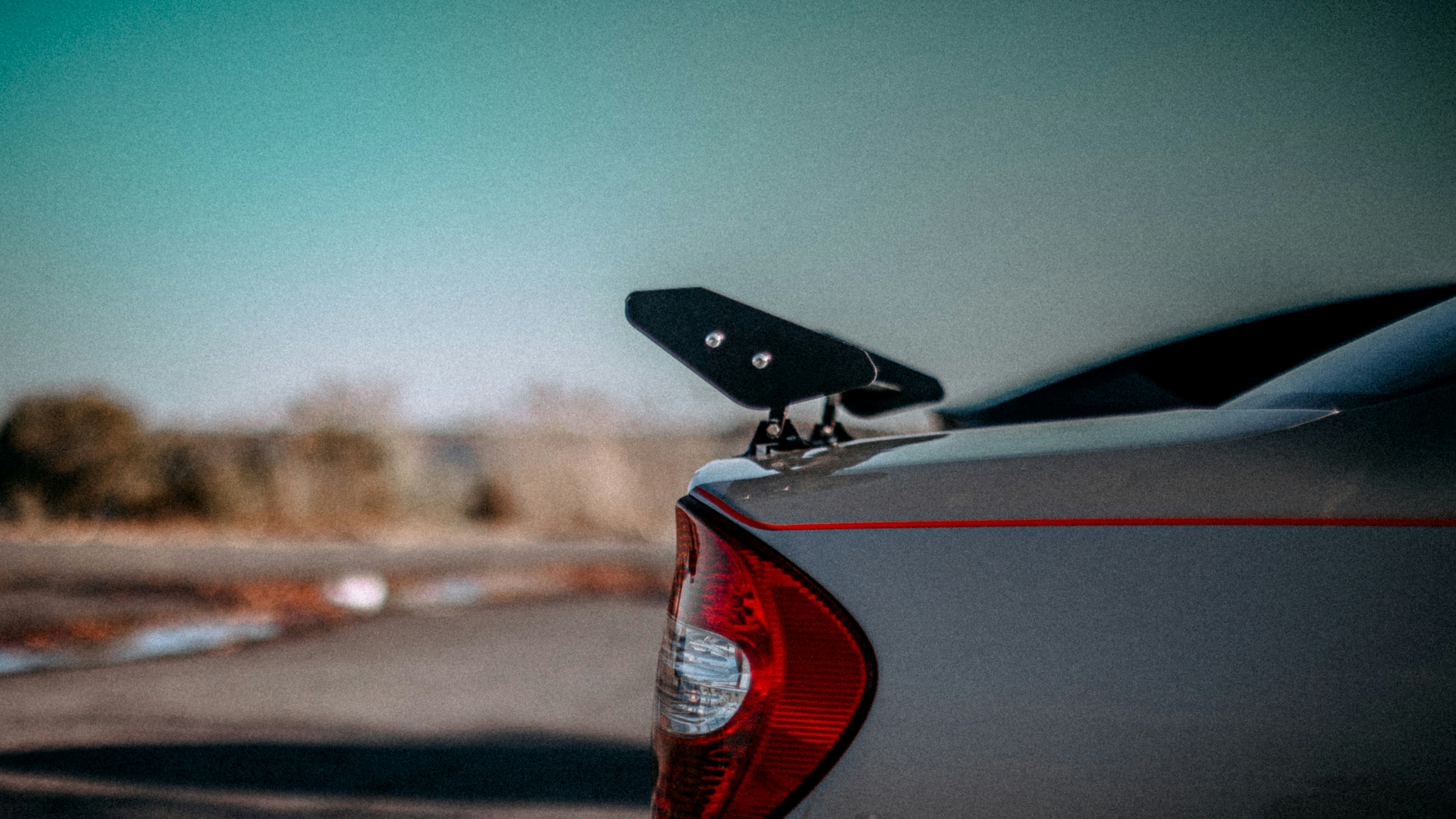 Spoiler traseiro em um carro com fundo desfocado.