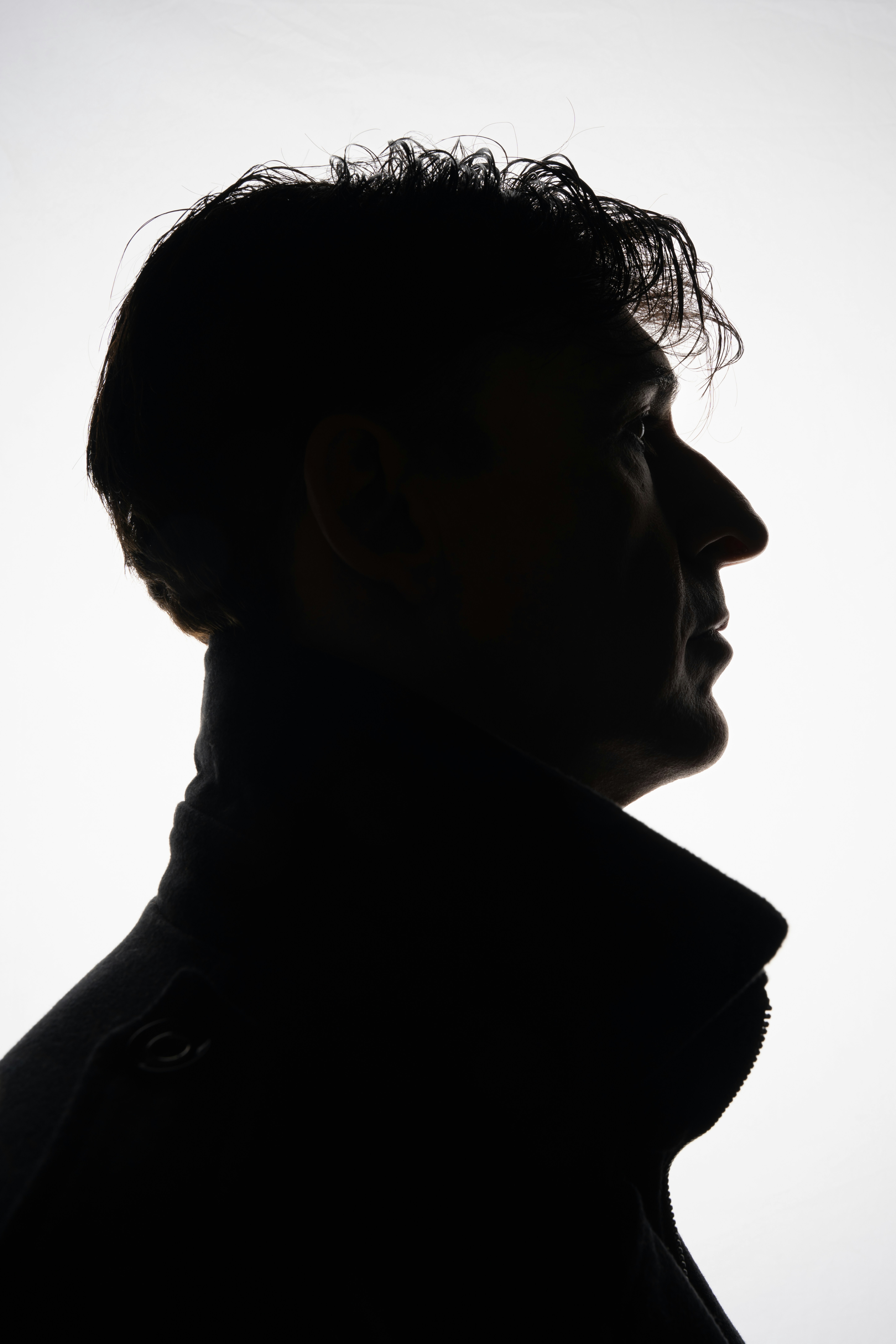 Silhouette profile of a man with curly hair.
