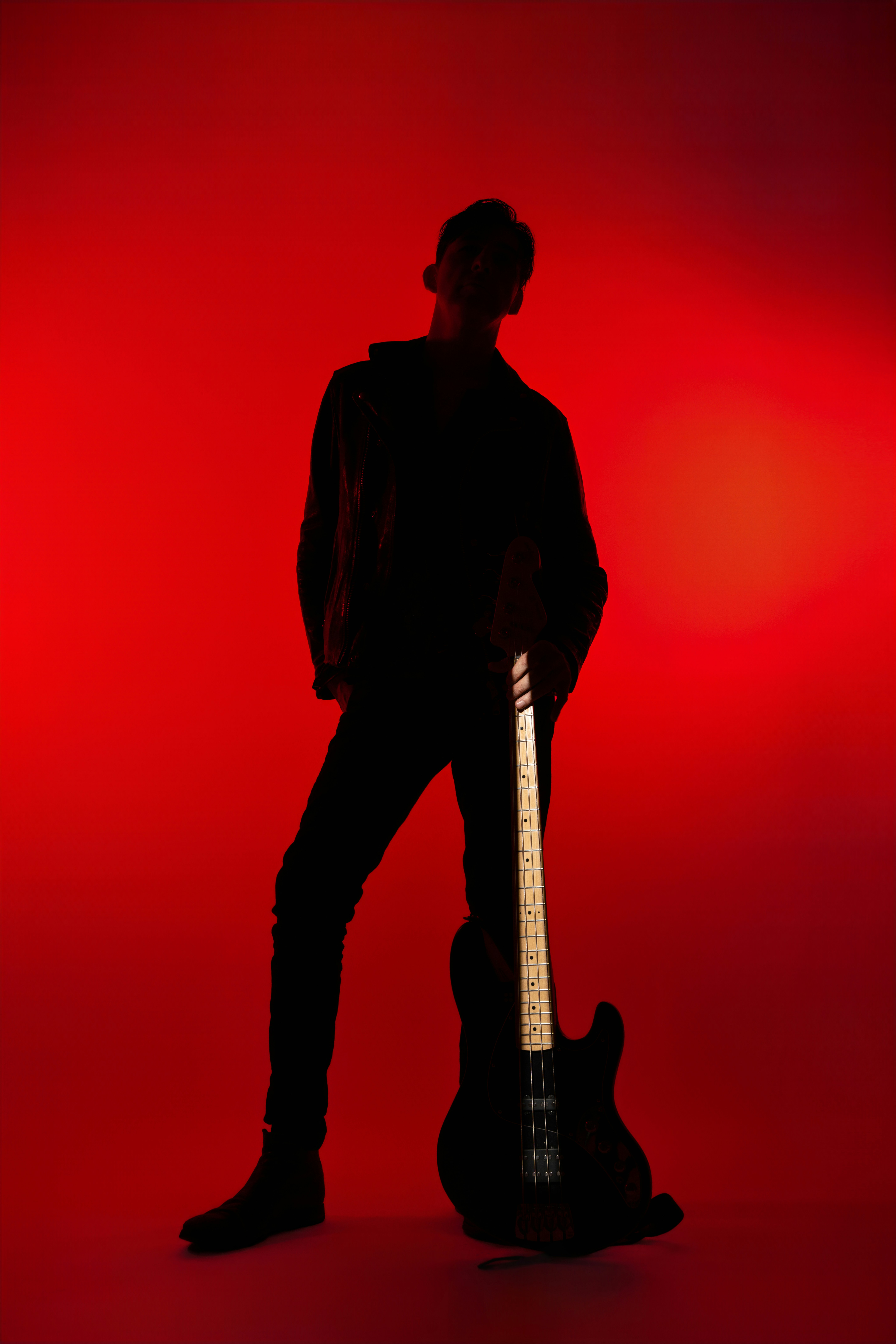 Silhouette of a man holding a bass guitar