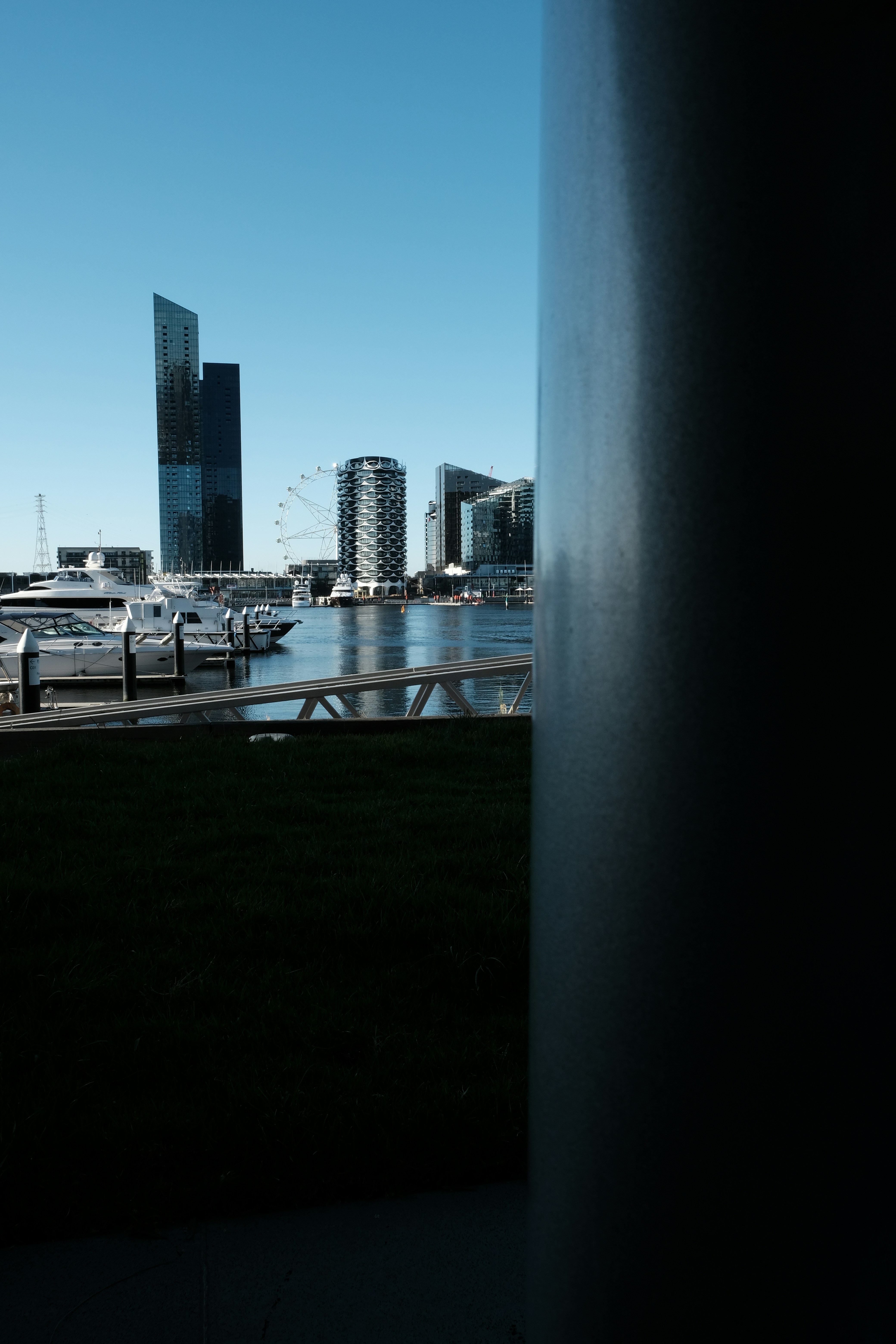 Modern cityscape with harbor and ferris wheel.