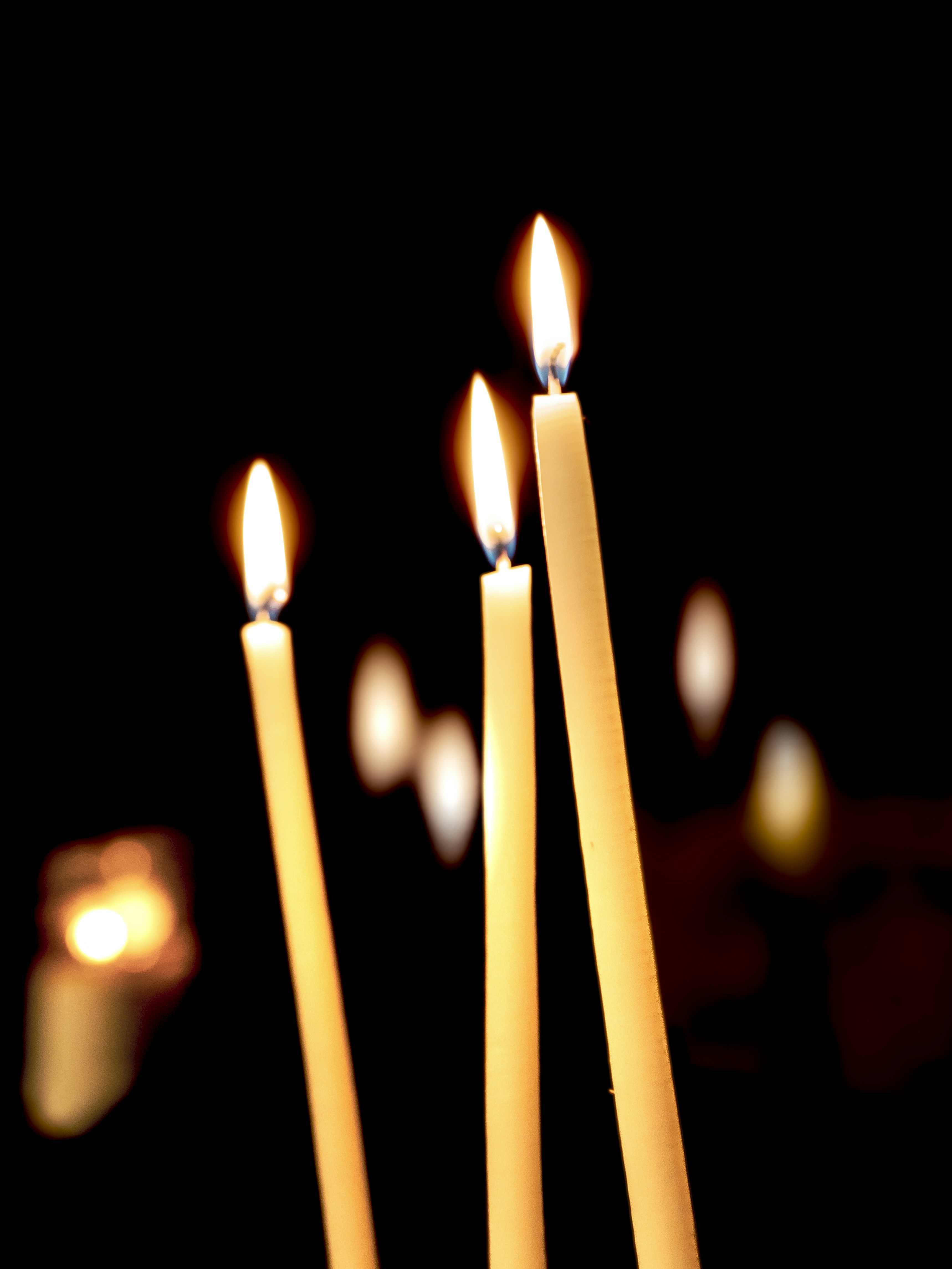 Three lit candles with soft bokeh background